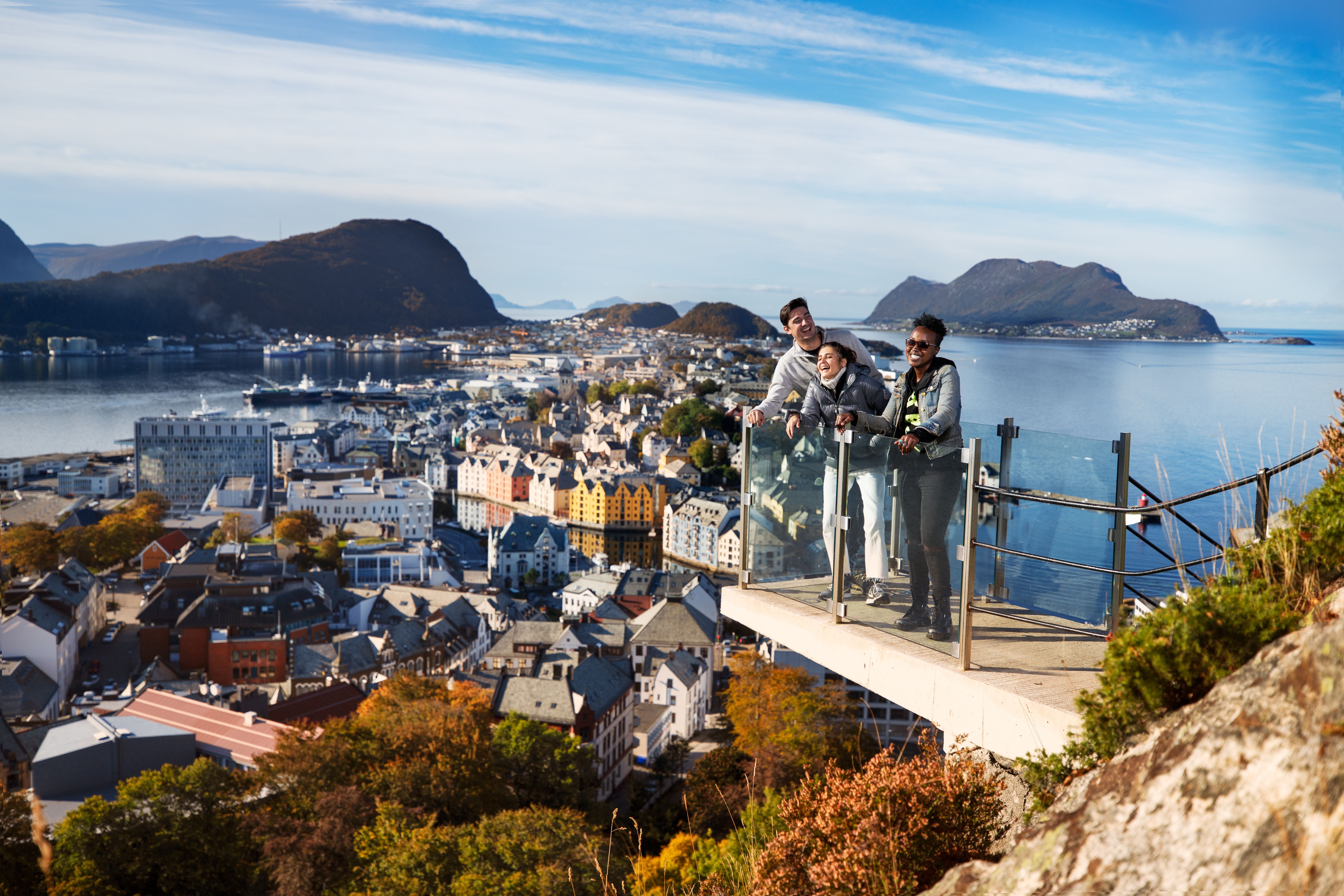 Drie mensen die op een uitkijkplatform staan op de berg Aksla in Ålesund, Fjord-Noorwegen