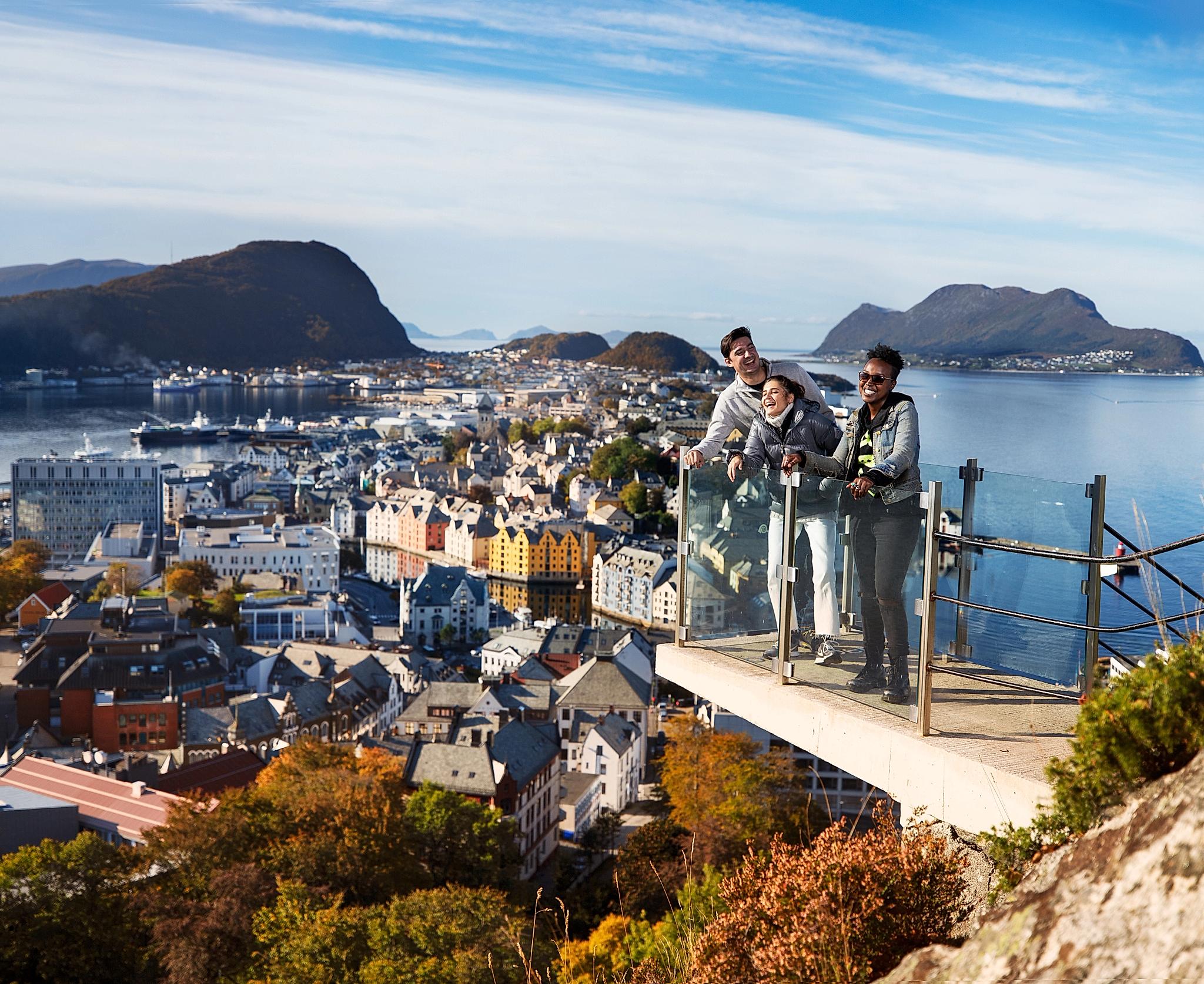 Drei Personen auf einer Aussichtsplattform am Berg Aksla in Ålesund, Fjord Norwegen