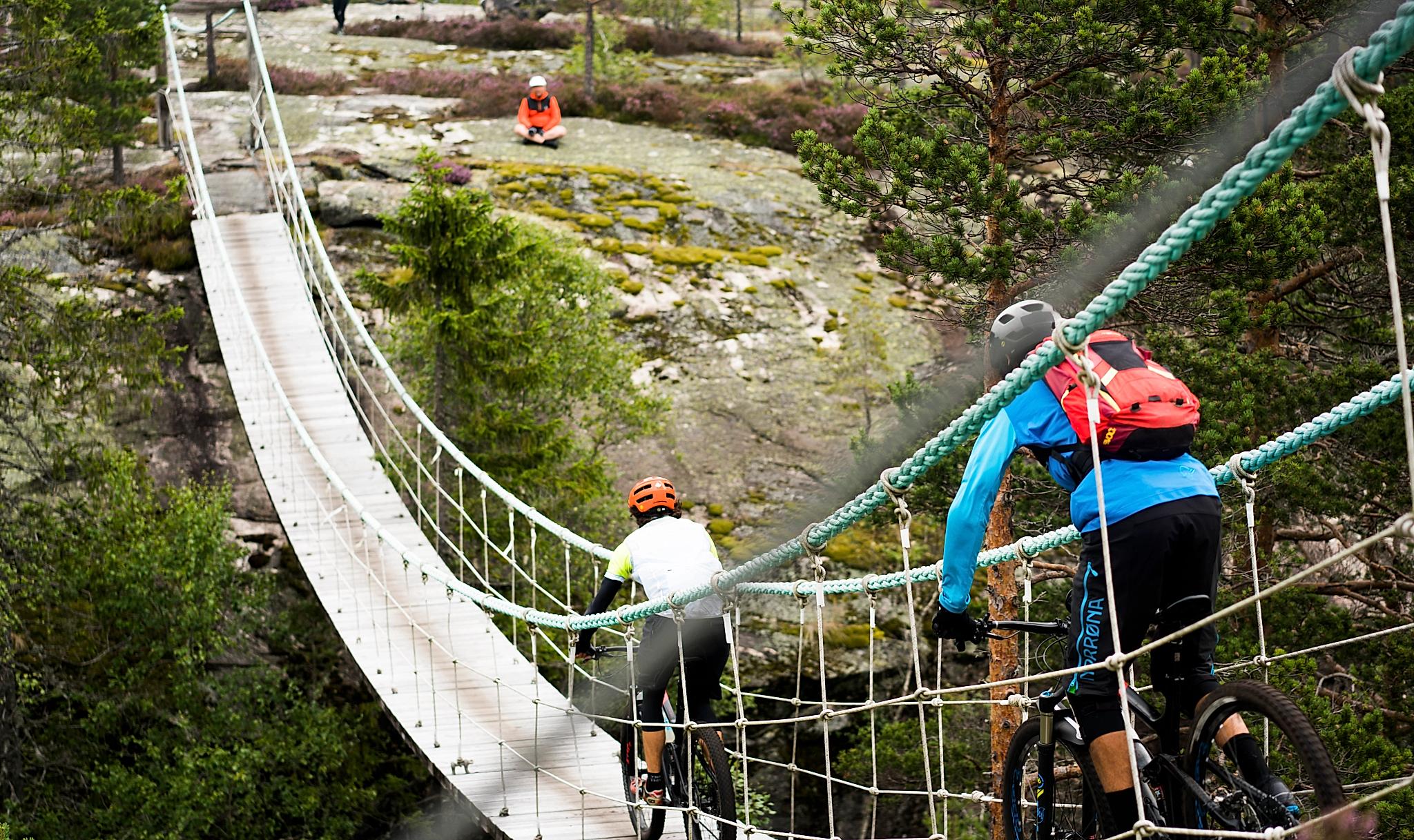 Flere personer sykler med terrengsykler ved Canvas Hotel i Norge.