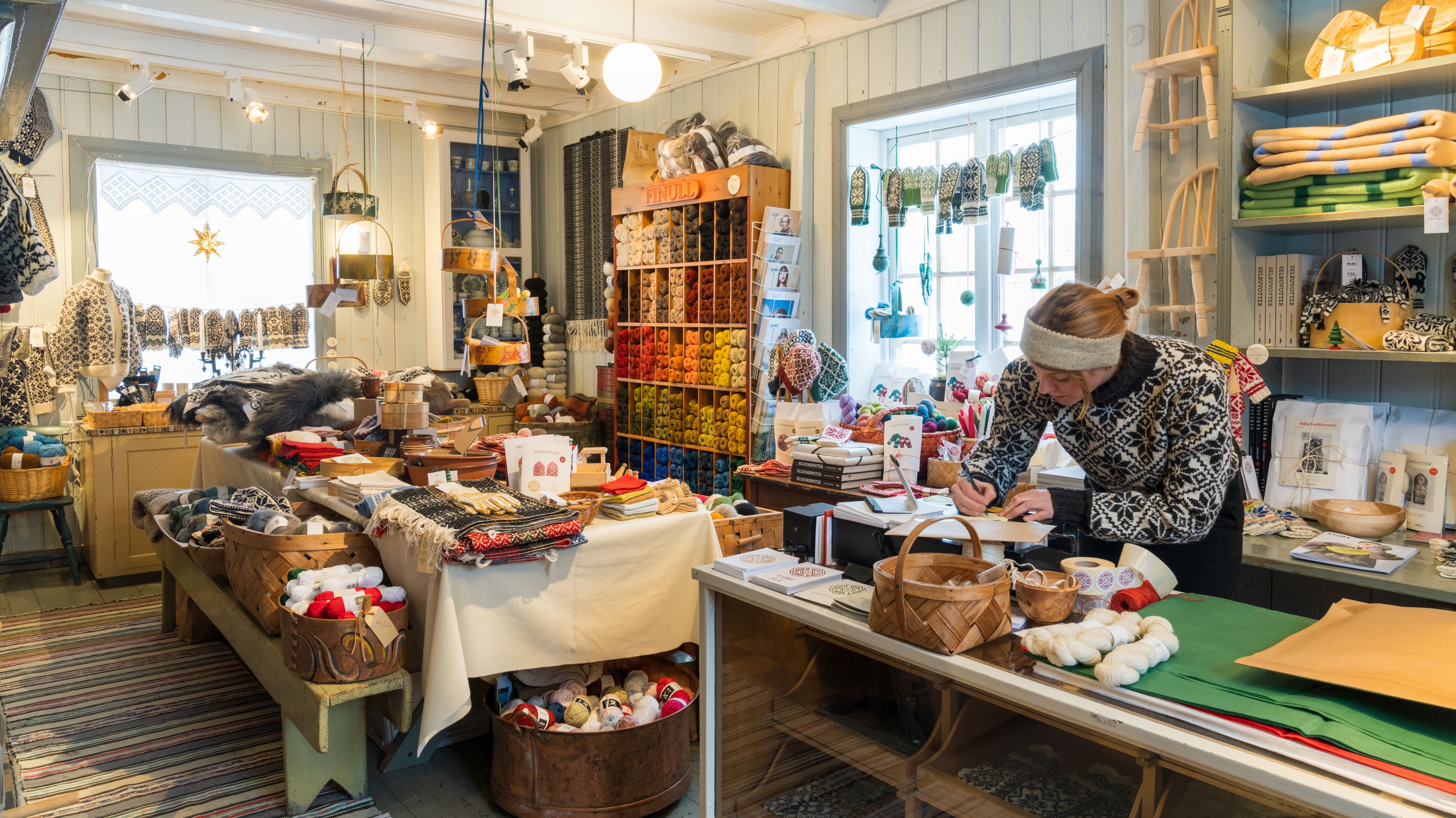 A woman working in the store at Selbu Husflidscentral, Trøndelag, Norway.