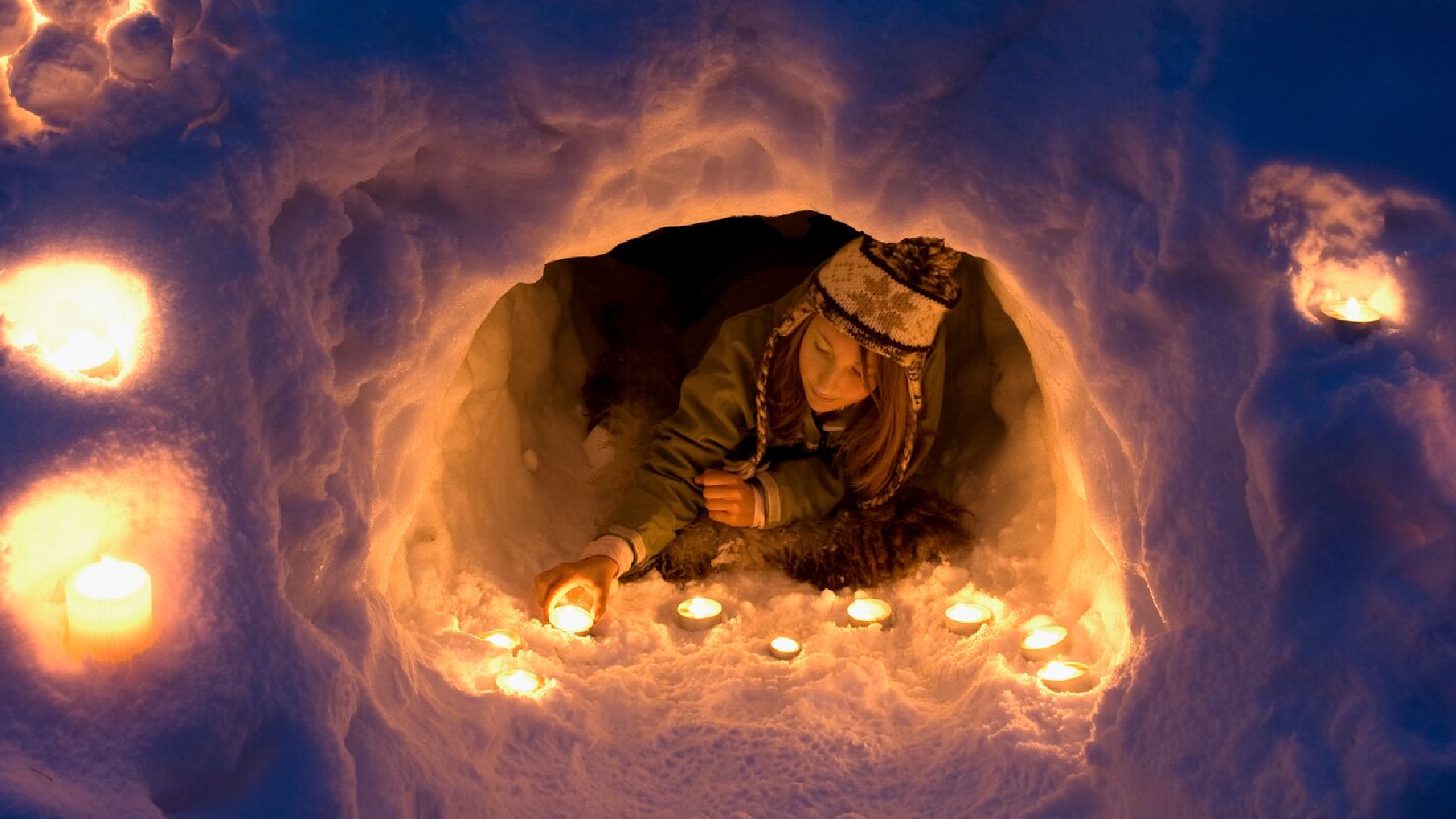 A girl lights a candle in a snow igloo in Trysil in Eastern Norway