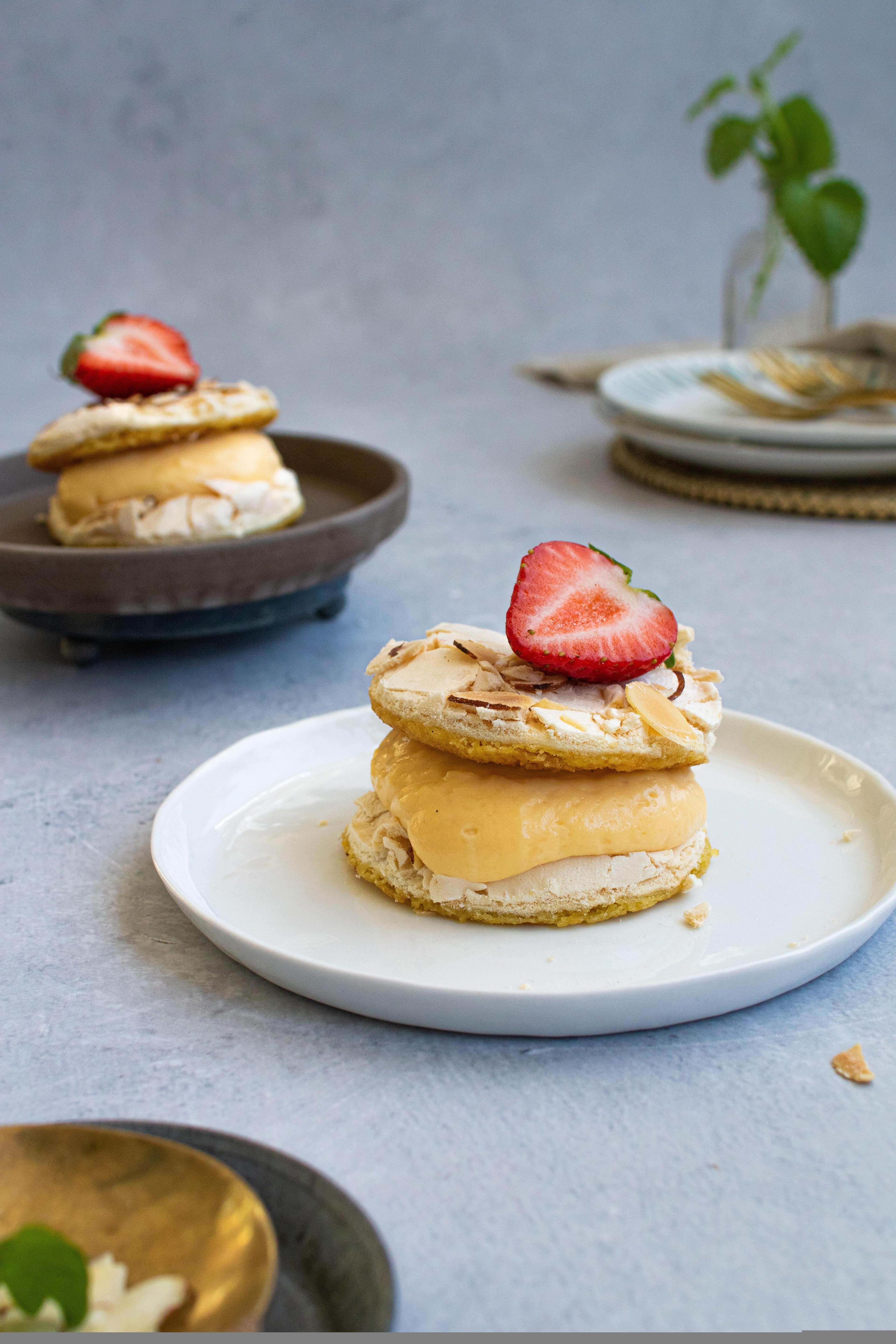 Portion cakes of Kvæfjordkake topped with almonds and strawberries