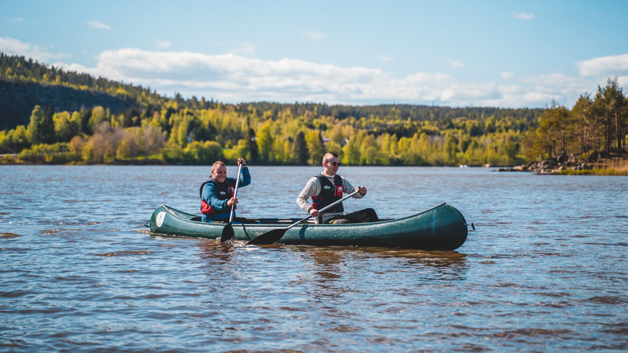 Two persons in a canoe on the Halden canal in summer, Eastern Norway.