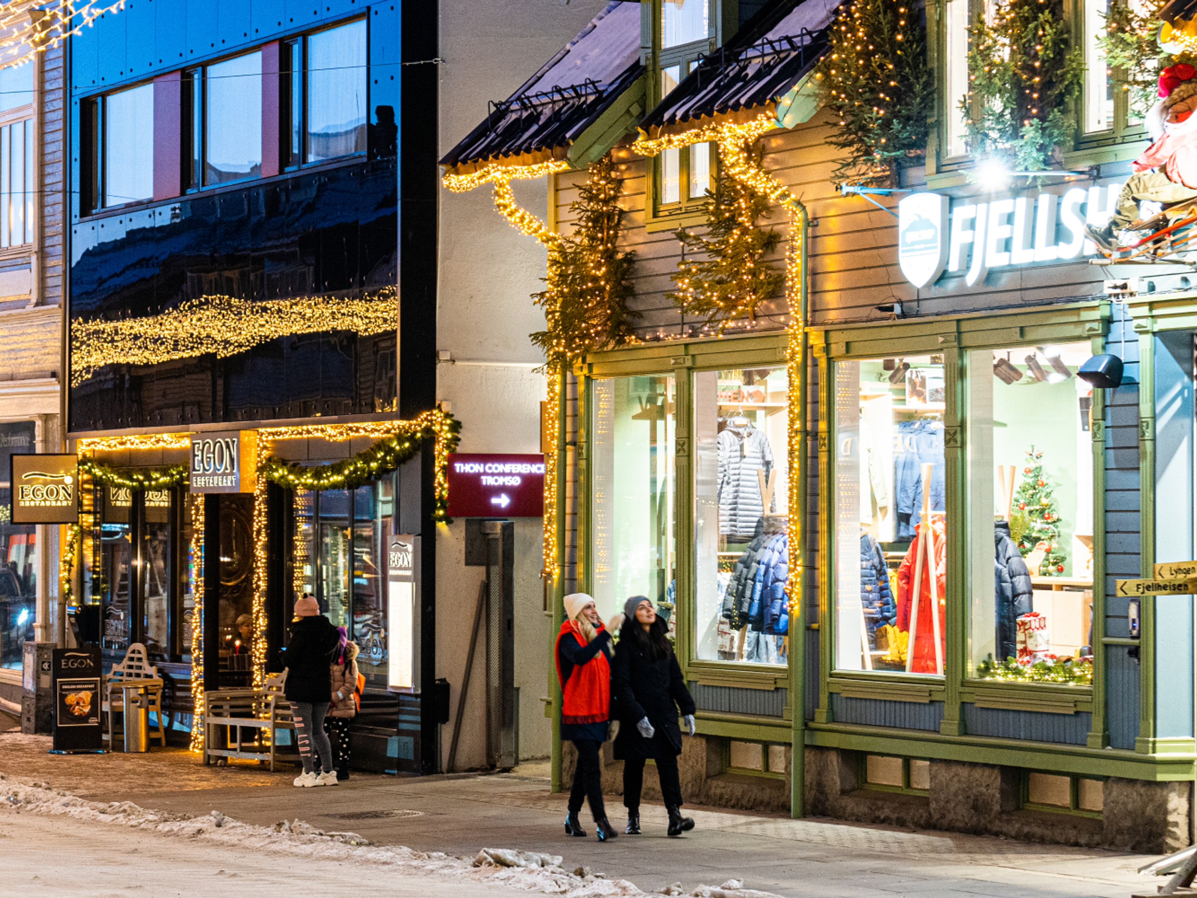 Two girls strolling in the Christmas decorated streets in Tromsø