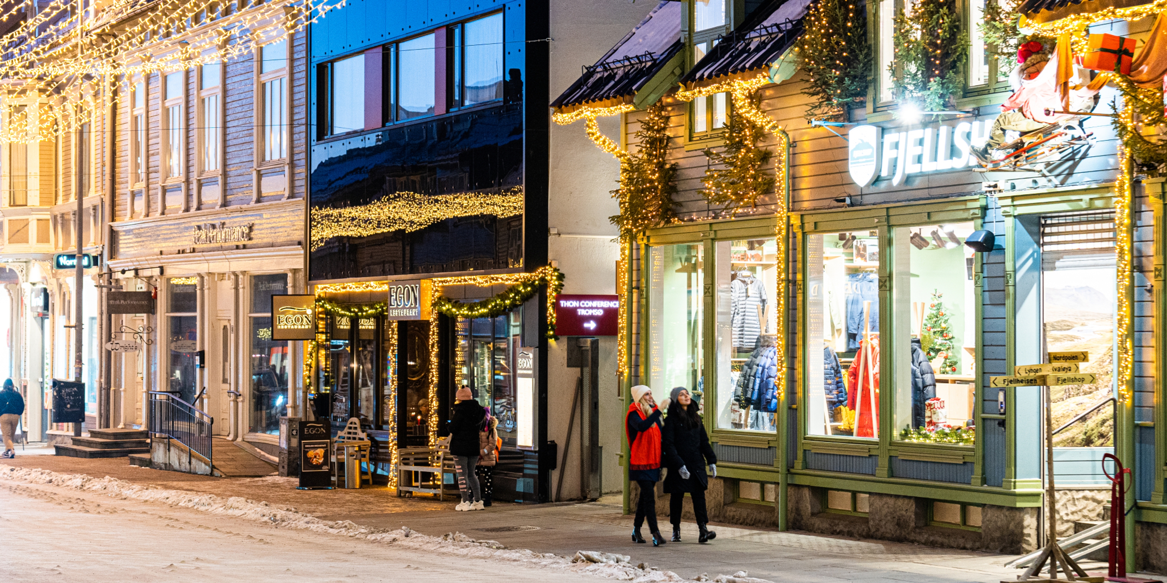 Two girls strolling in the Christmas decorated streets in Tromsø