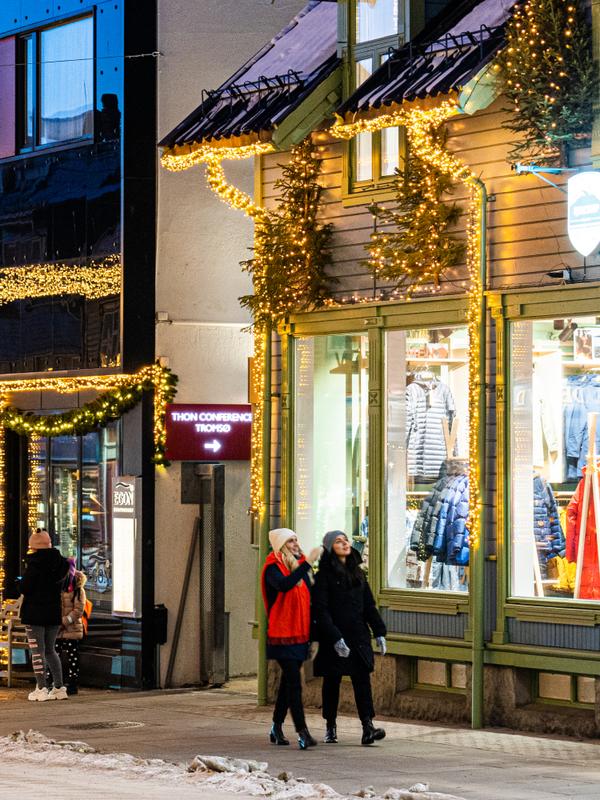 Two girls strolling in the Christmas decorated streets in Tromsø