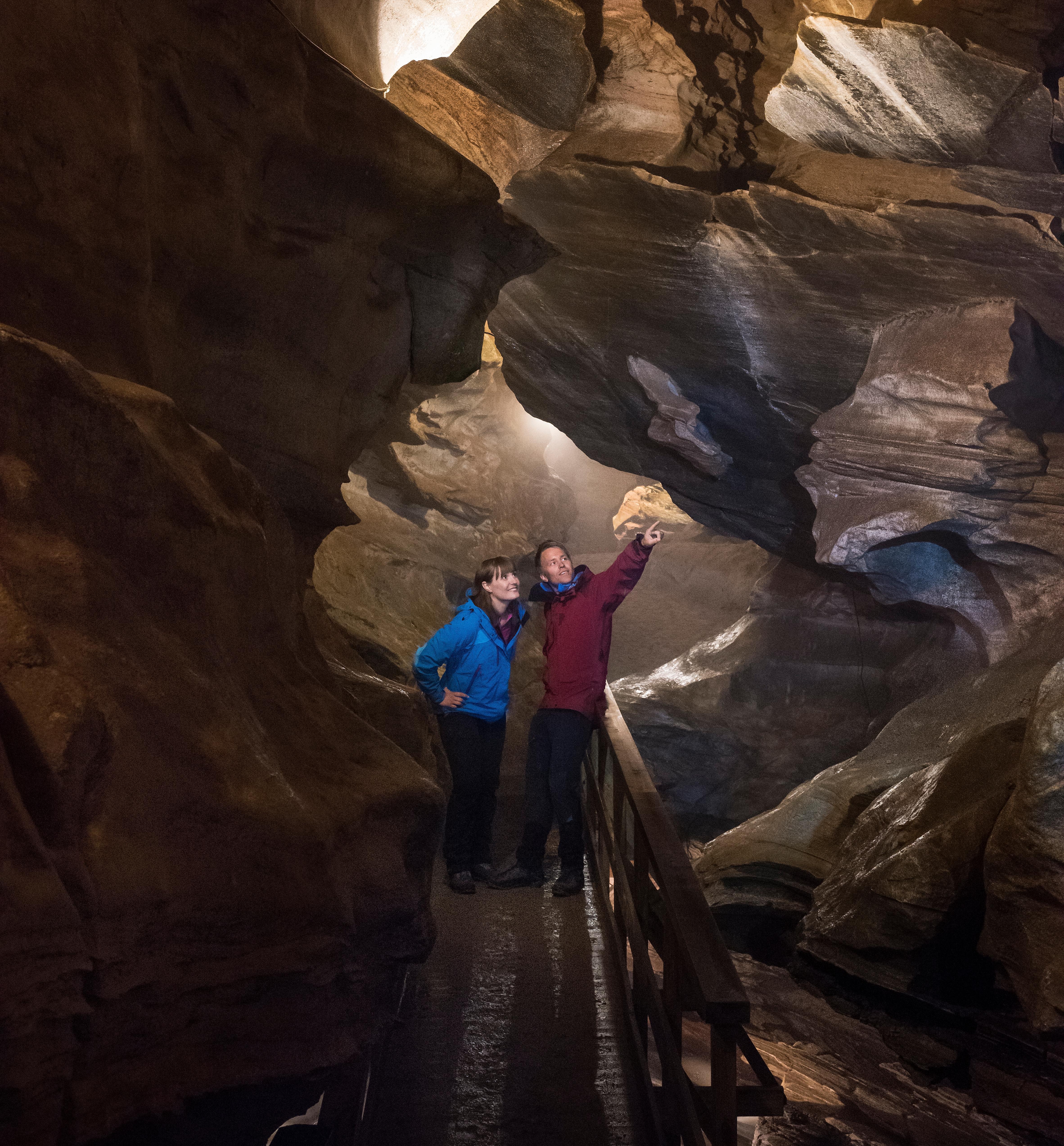 Two people inside the Grønligrotta cave in Helgeland in Northern Norway