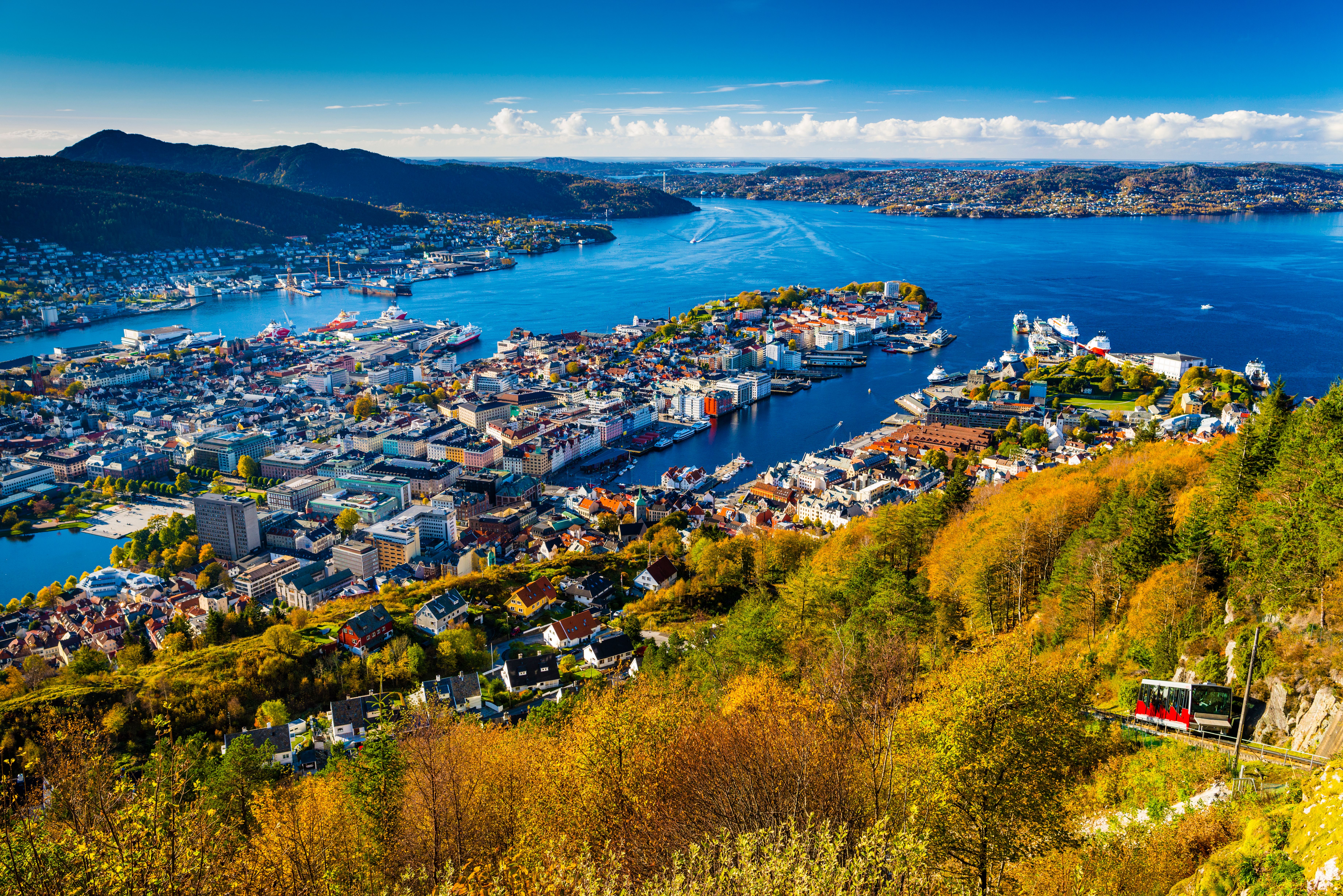 The Fløibanen funicular on its way up Mount Fløyen in Bergen, Fjord Norway, with a view of the city and the fjord
