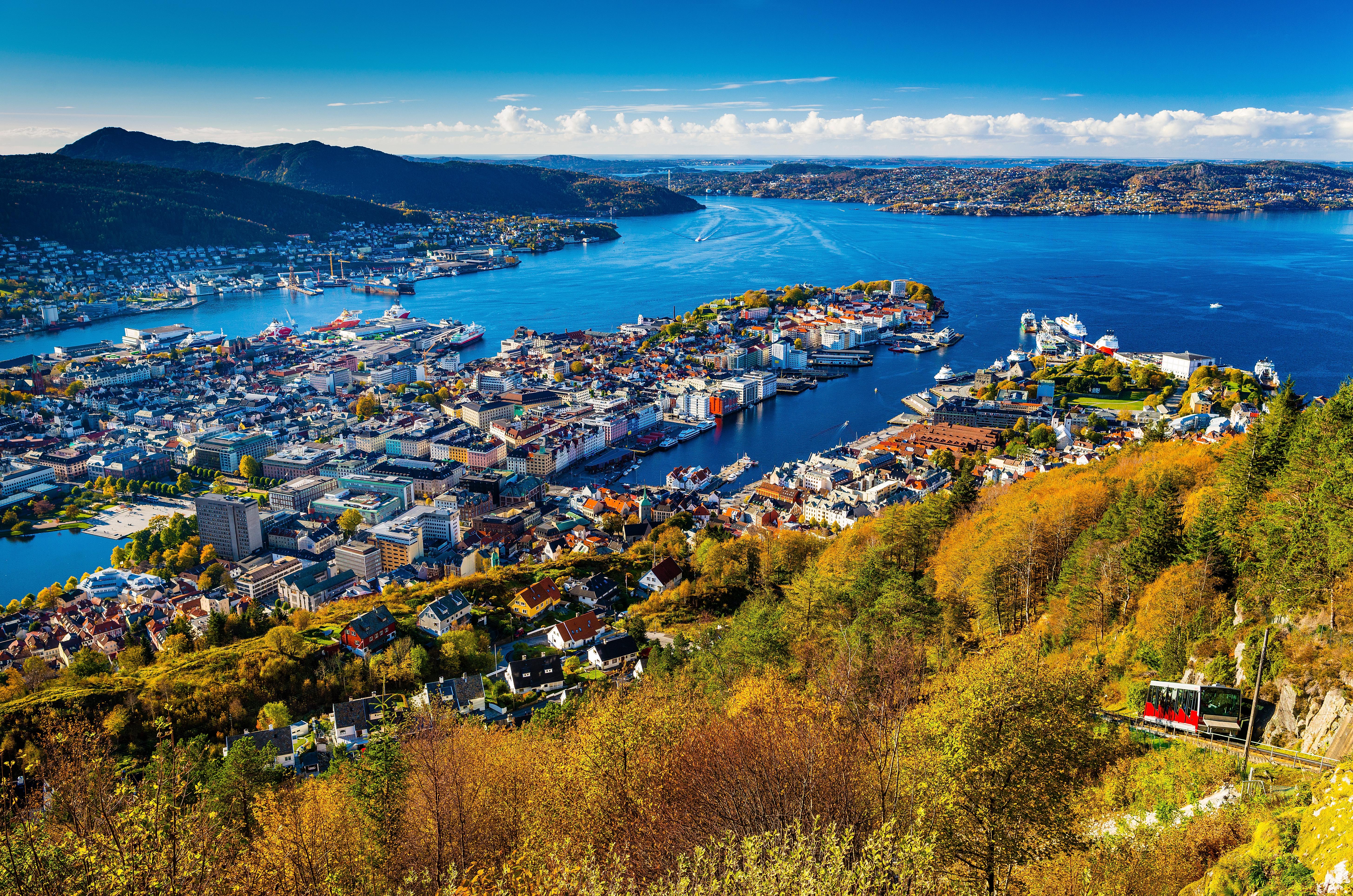 The Fløibanen funicular on its way up Mount Fløyen in Bergen, Fjord Norway, with a view of the city and the fjord