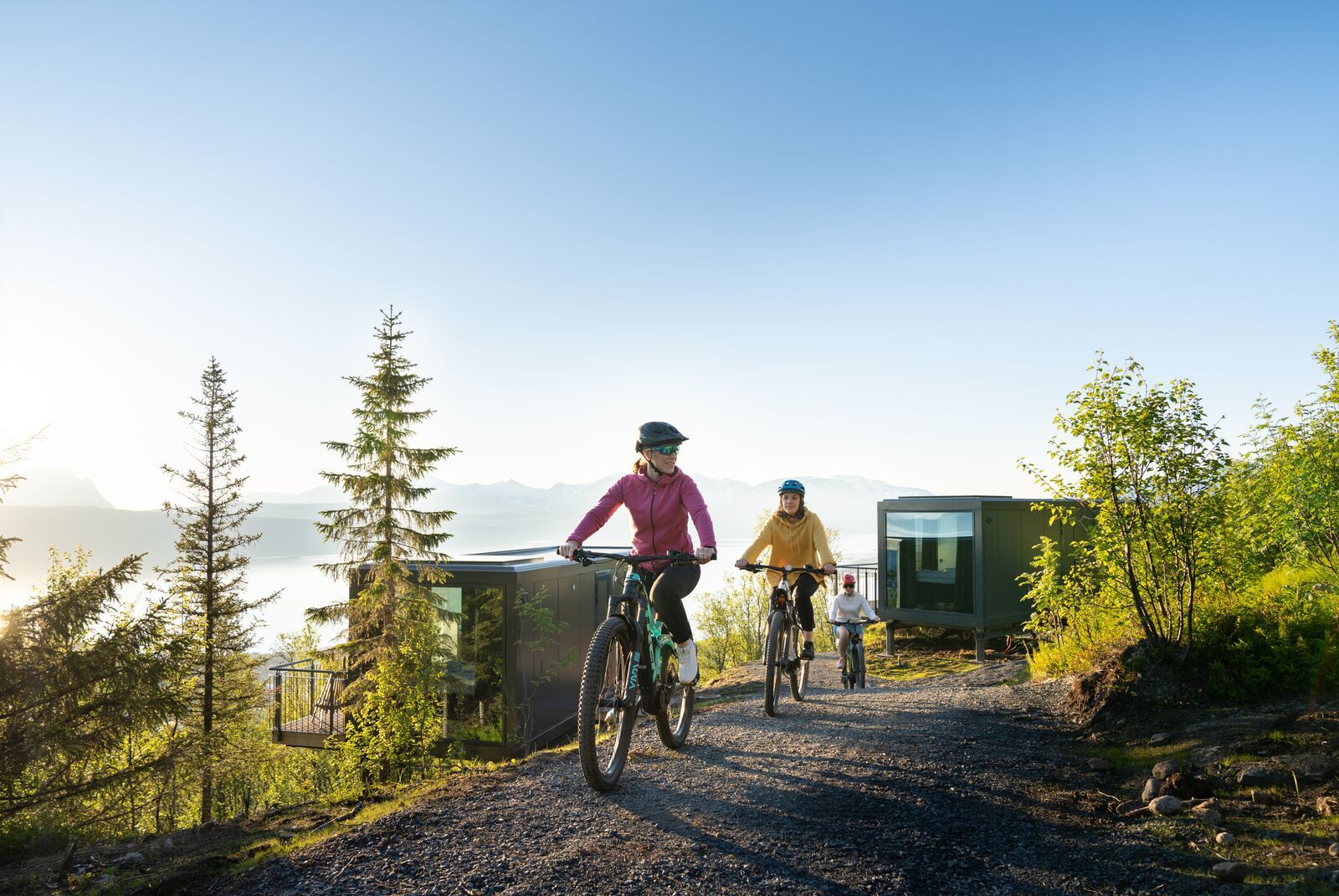 Three women biking under the midnight sun at Narvikfjellet