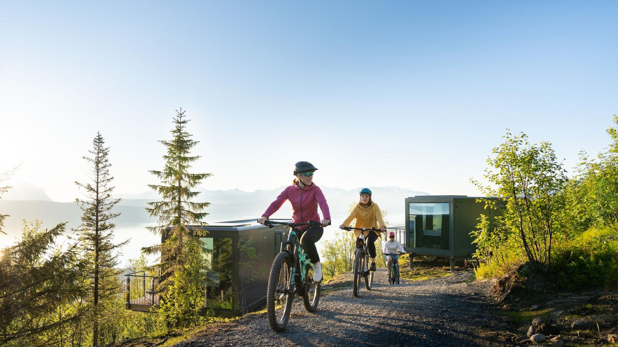 Tre kvinner på sykkeltur under midnattssola på Narvikfjellet