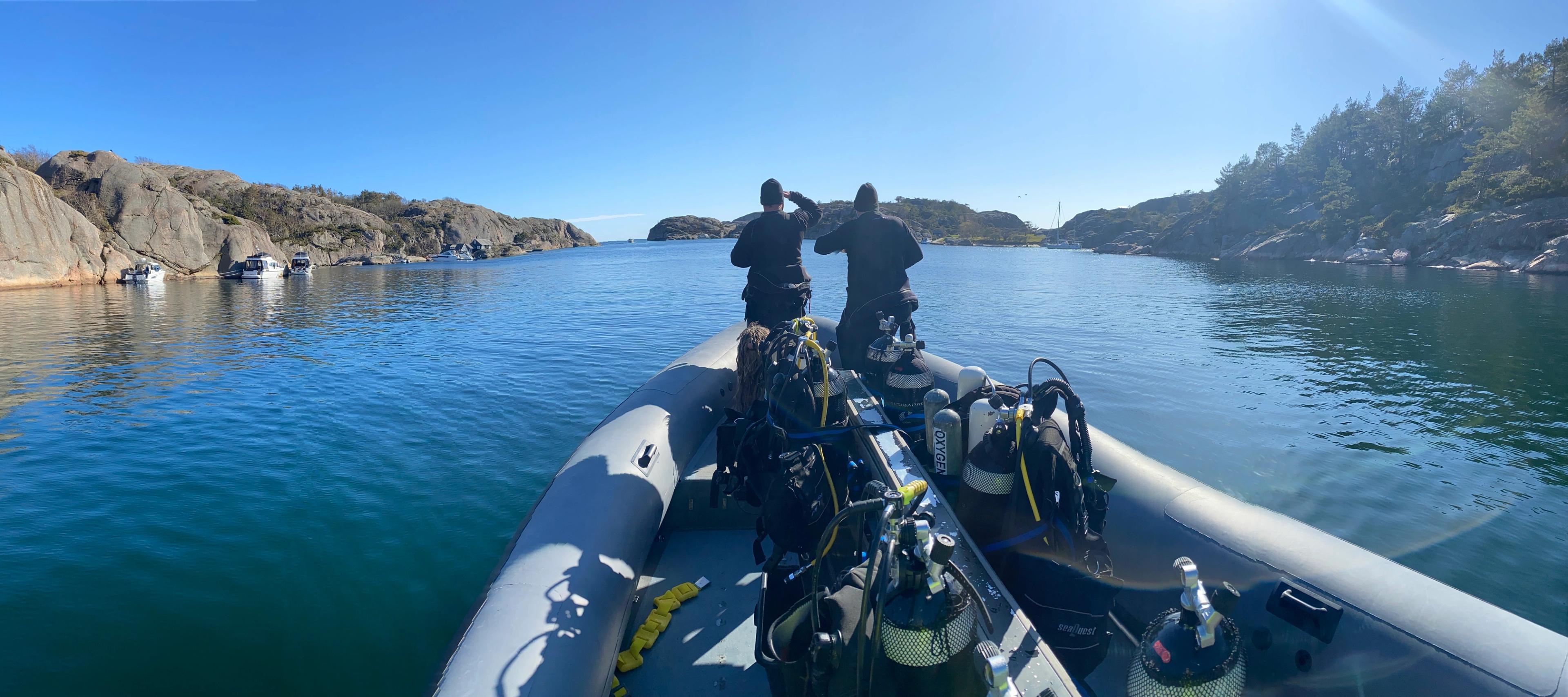 Two people in a boat, ready to scuba dive in Southern Norway