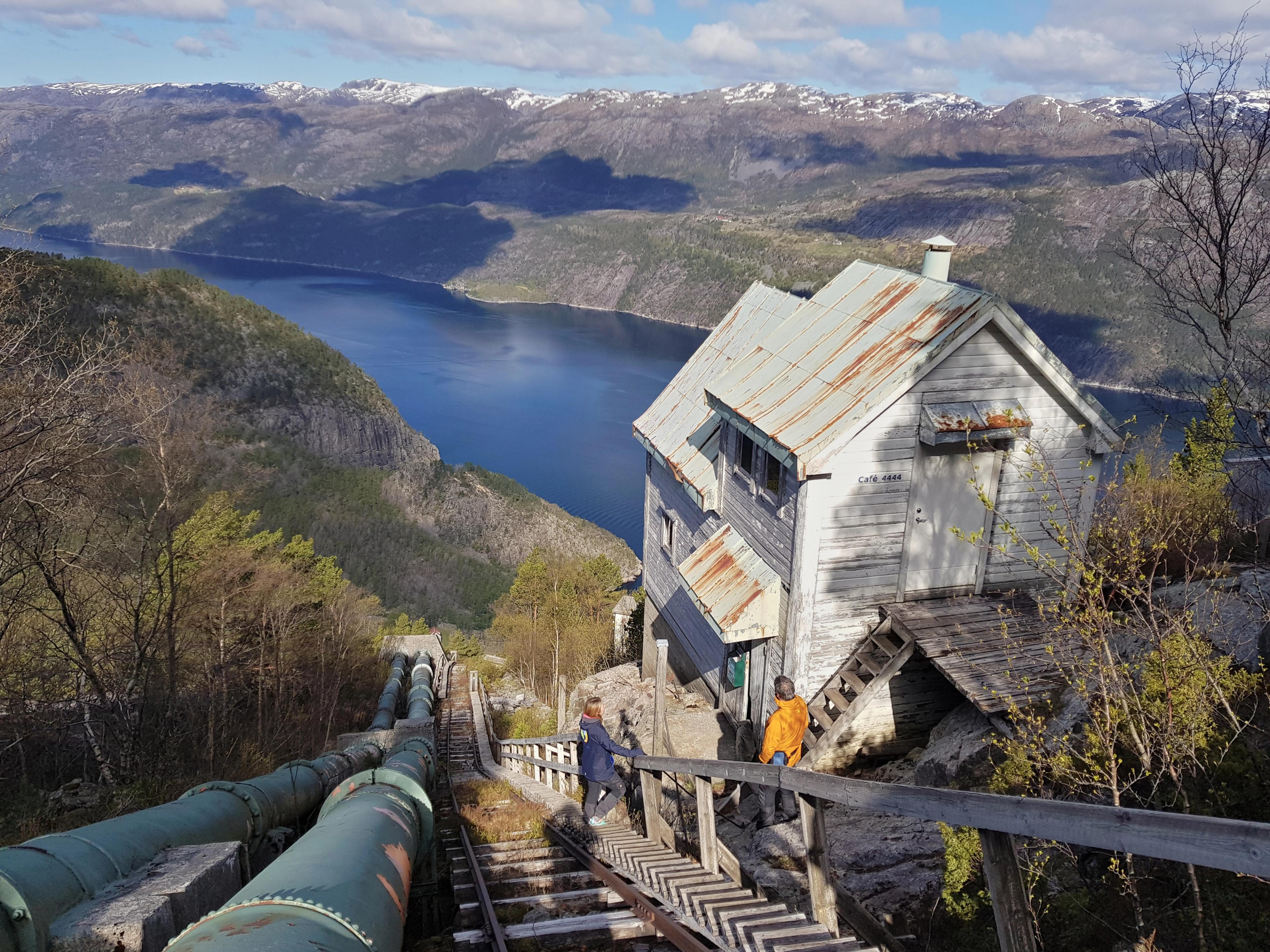 People hiking up wooden stairs to reach the top of a mountain