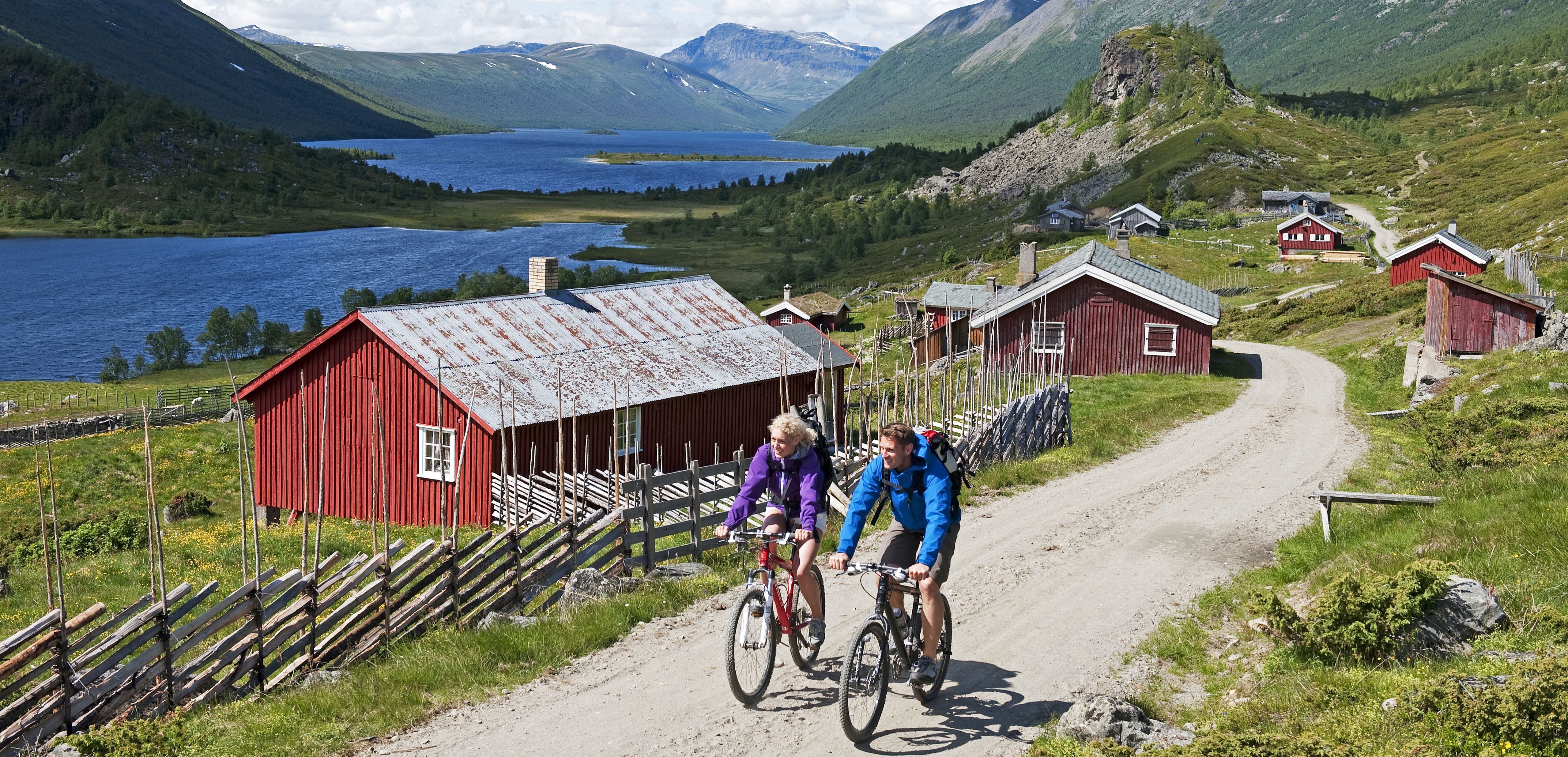 Two people cycling in scenic surroundings in Stø in Valdres, Eastern Norway