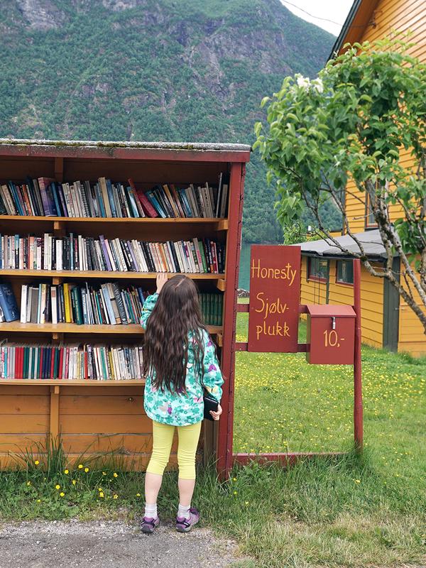 En jente ser på bøker i bokhandelen Sjølvplukk i Den norske bokbyen i Fjærland, Sogn og Fjordane