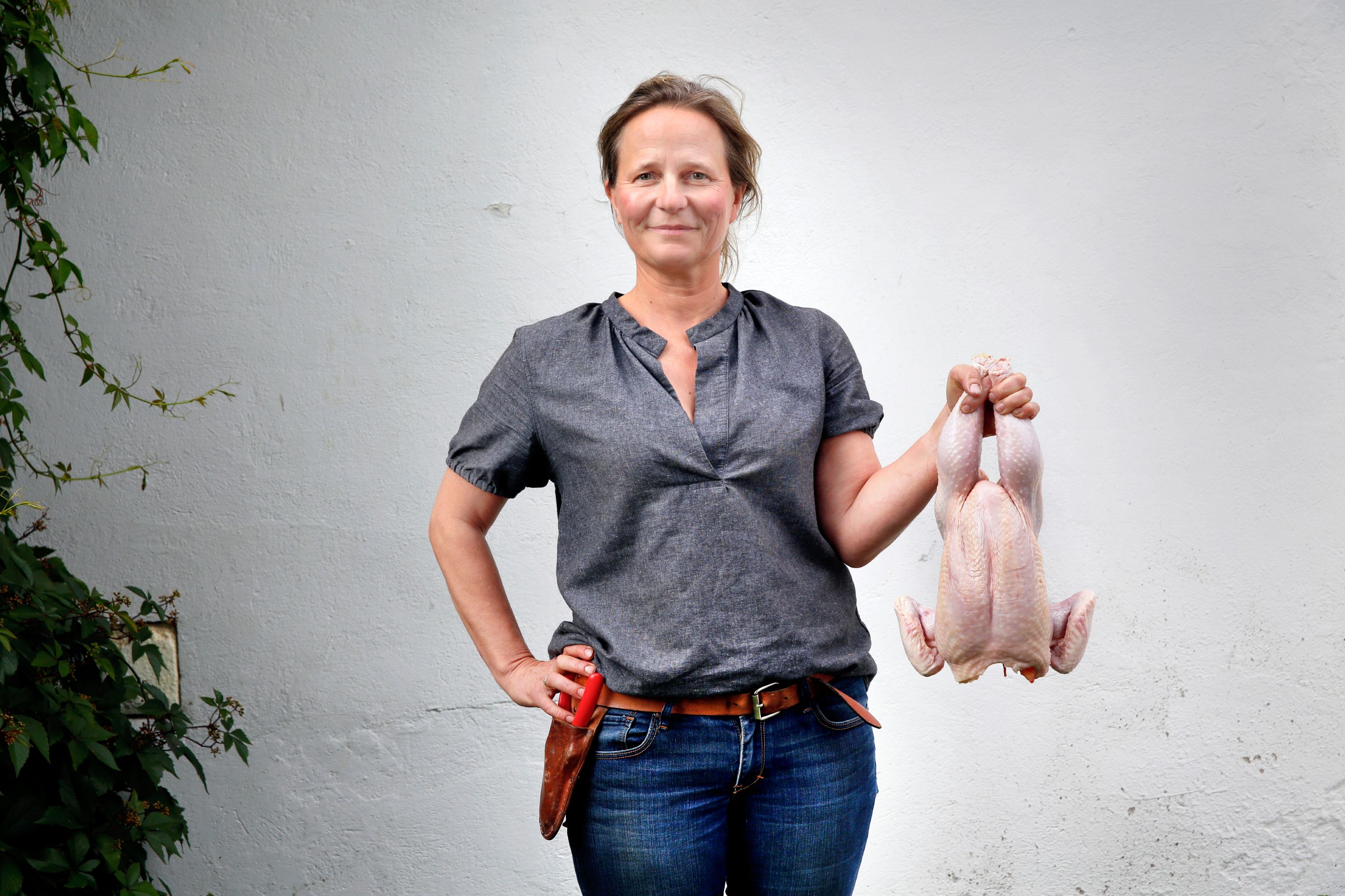 Marianne hold a chicken at the Hovelsrud farm by lake Mjøsa, Eastern Norway.