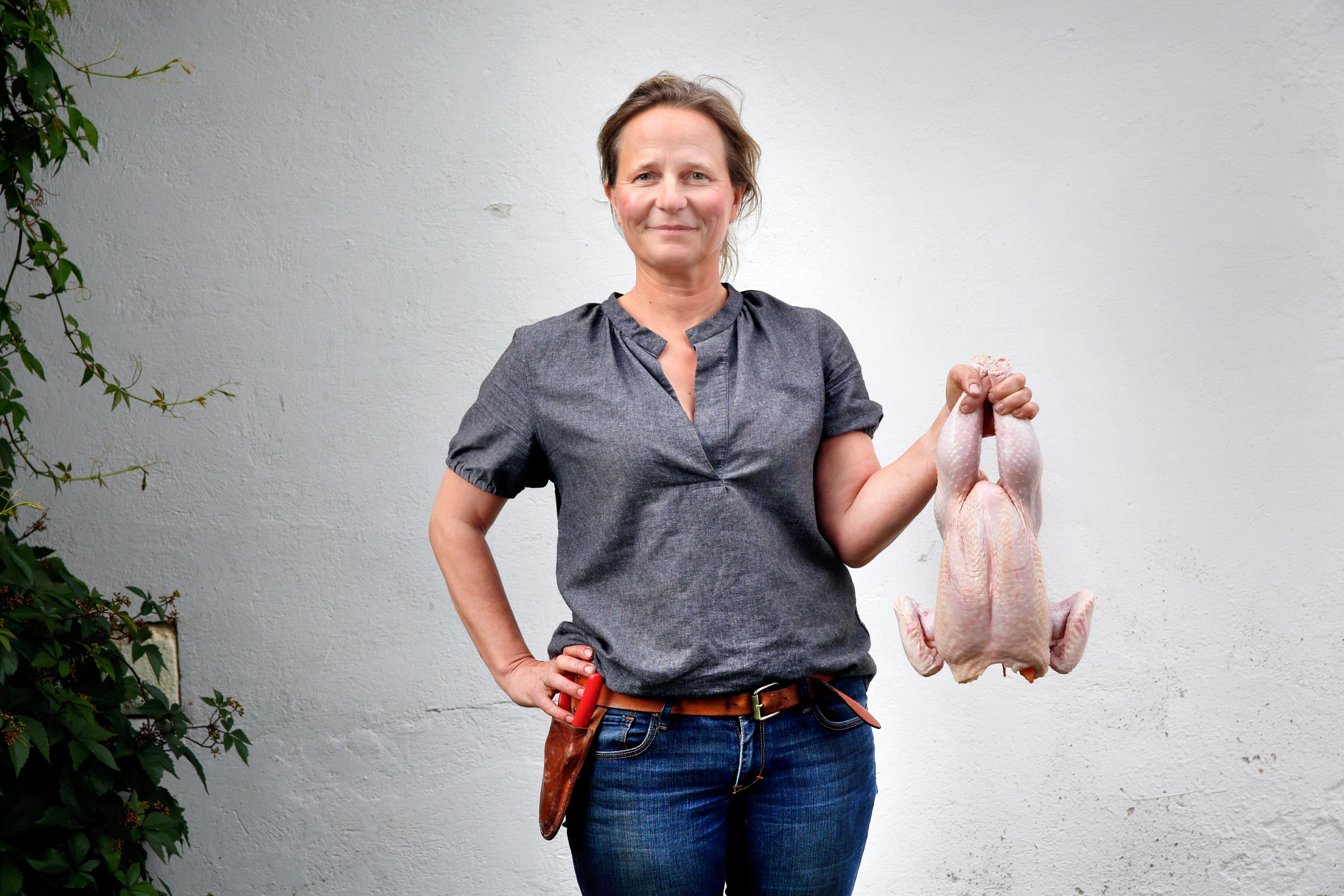 Marianne hold a chicken at the Hovelsrud farm by lake Mjøsa, Eastern Norway.