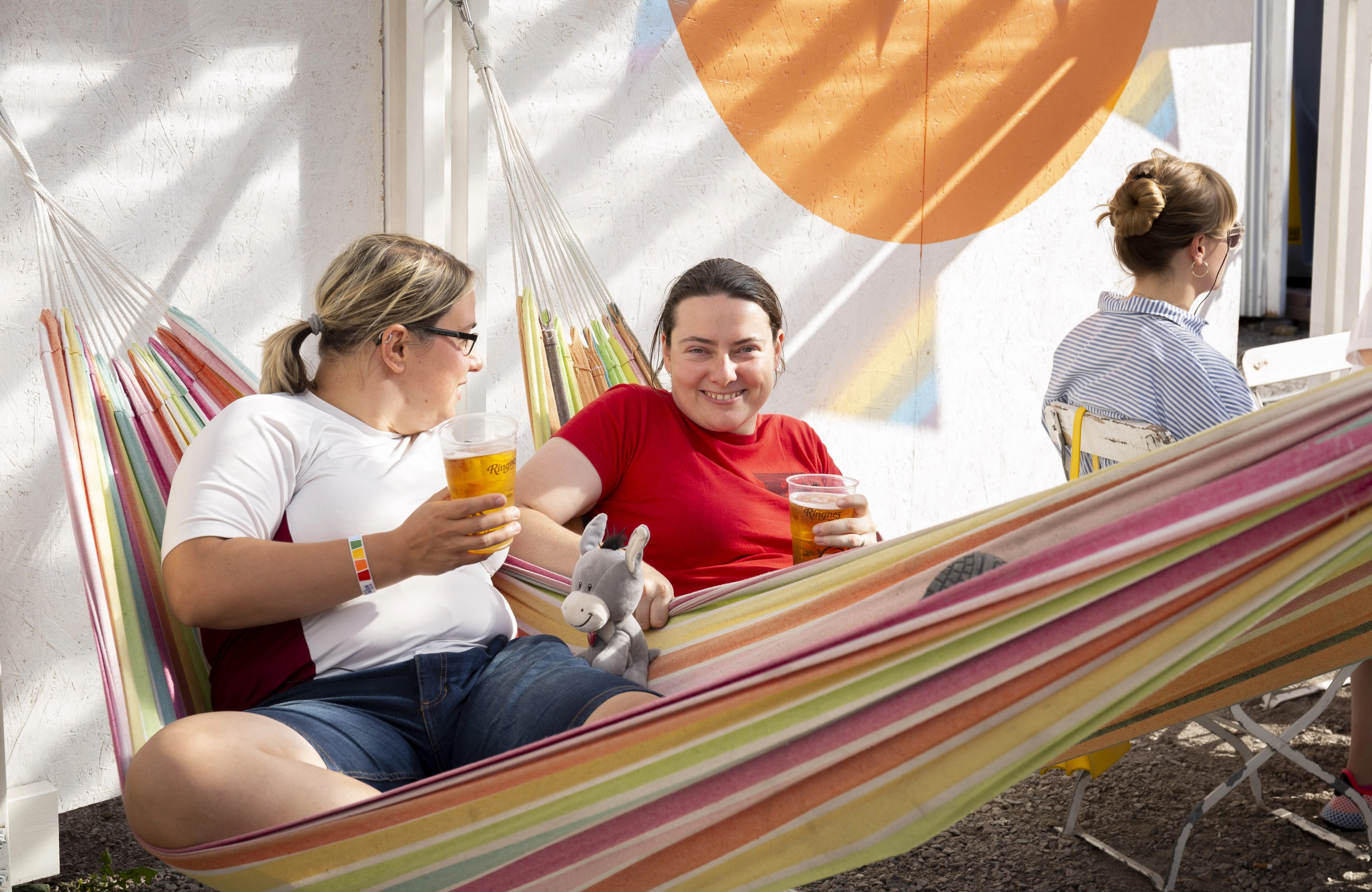 Anna and Klára enjoying a drink in a hammock at Oslo Pride