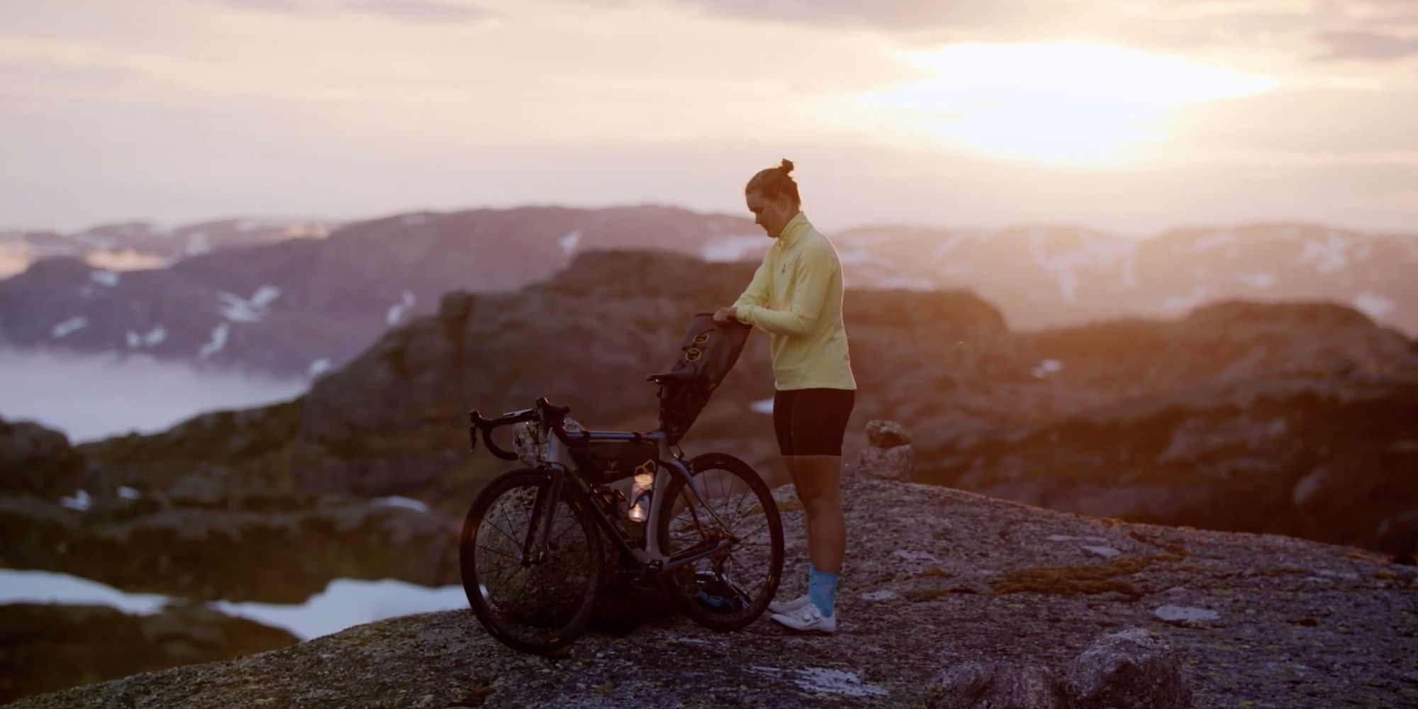 Girl with bike on top of mountain