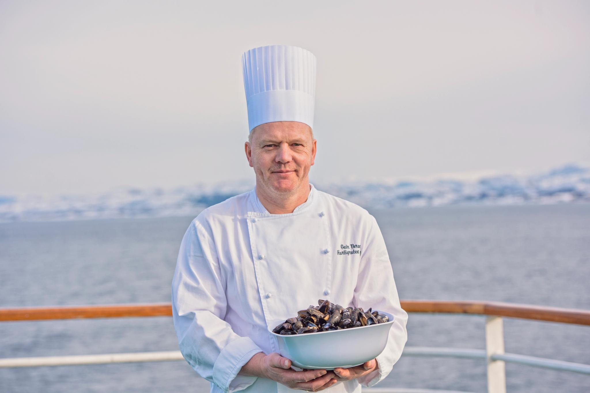 En kokk som holder blåskjell på dekk på Hurtigruten