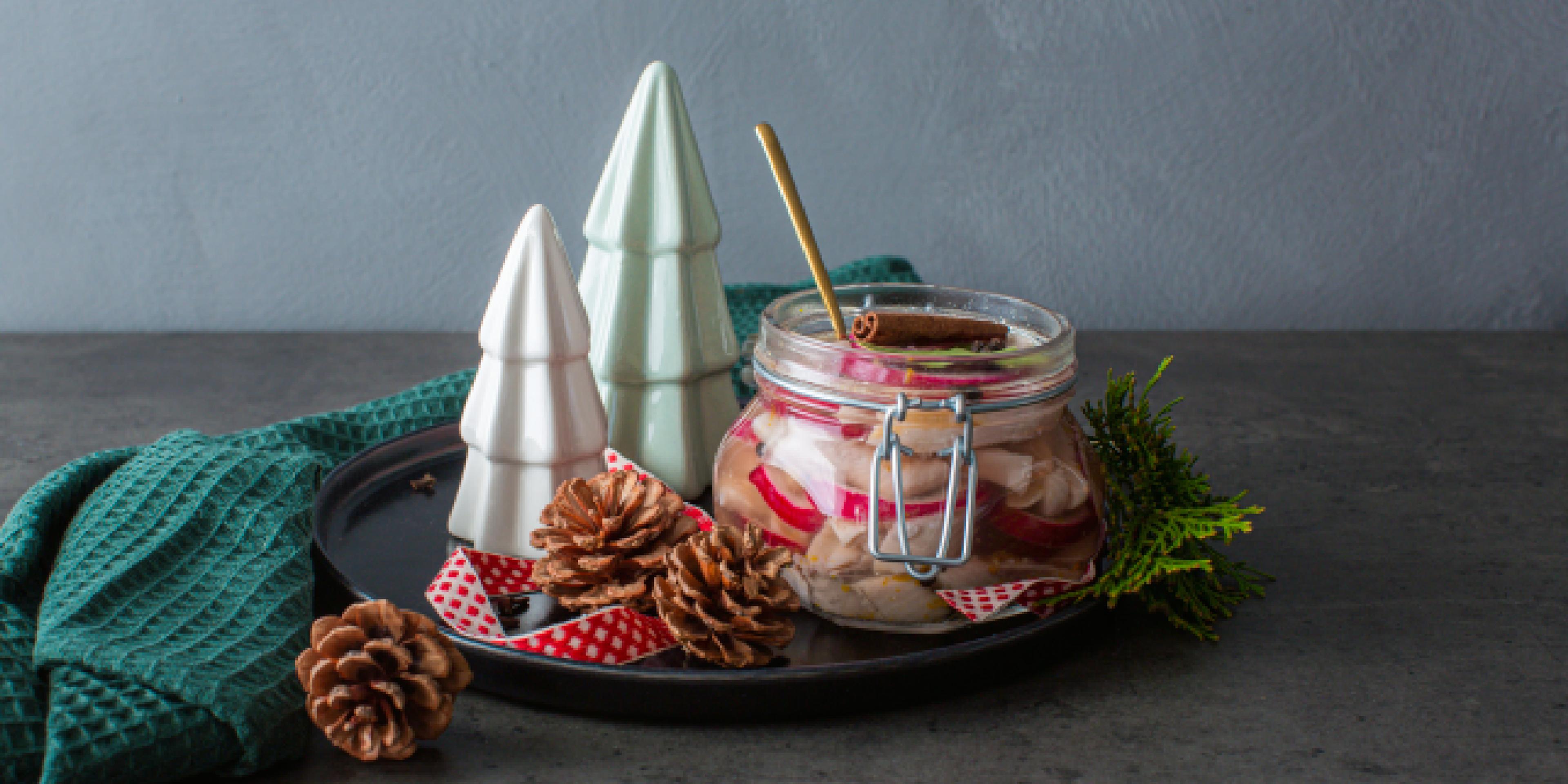 Traditional Norwegian pickled herring in a glass jar.