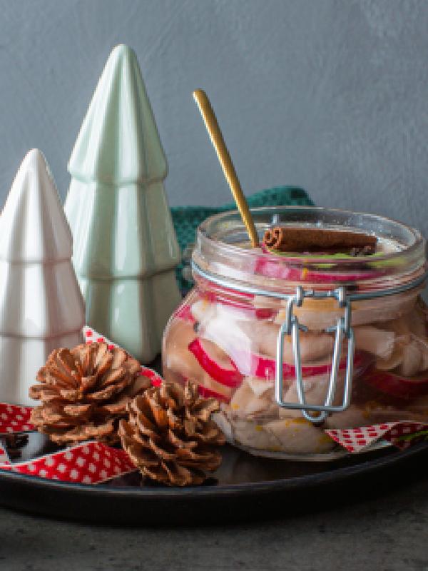 Traditional Norwegian pickled herring in a glass jar.