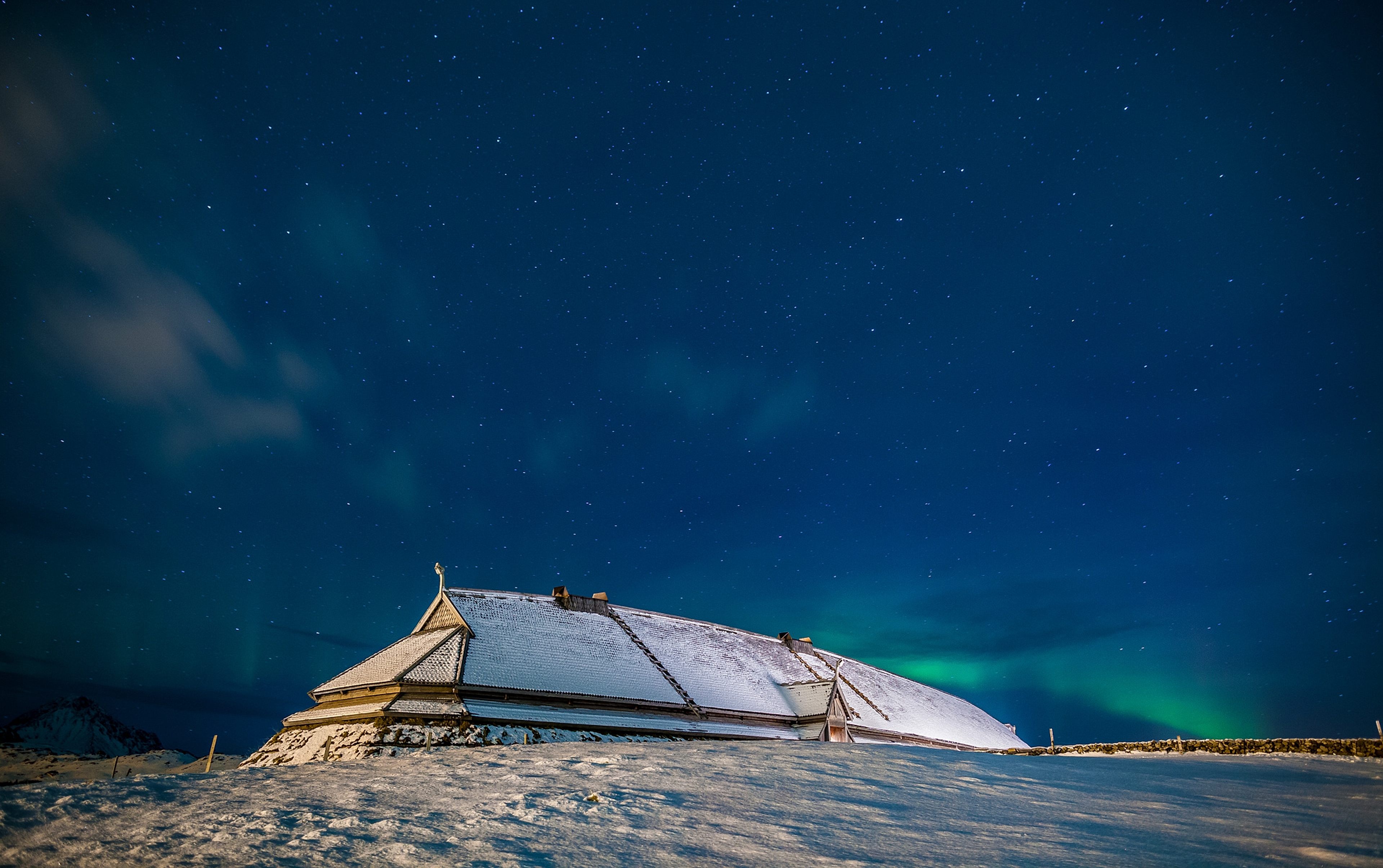 Langhus på Lofotr museet under midnattsola, Lofoten