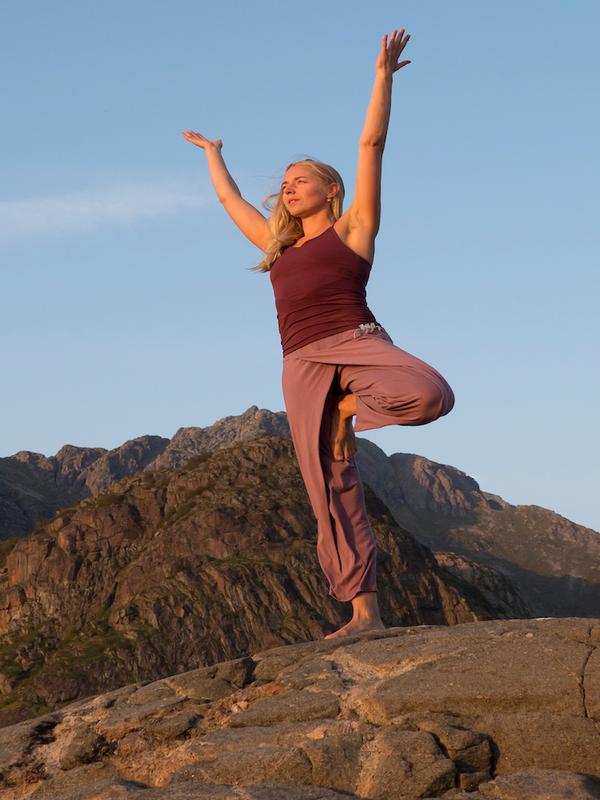 A woman doing yoga while on a hike in Lofoten, Northern Norway