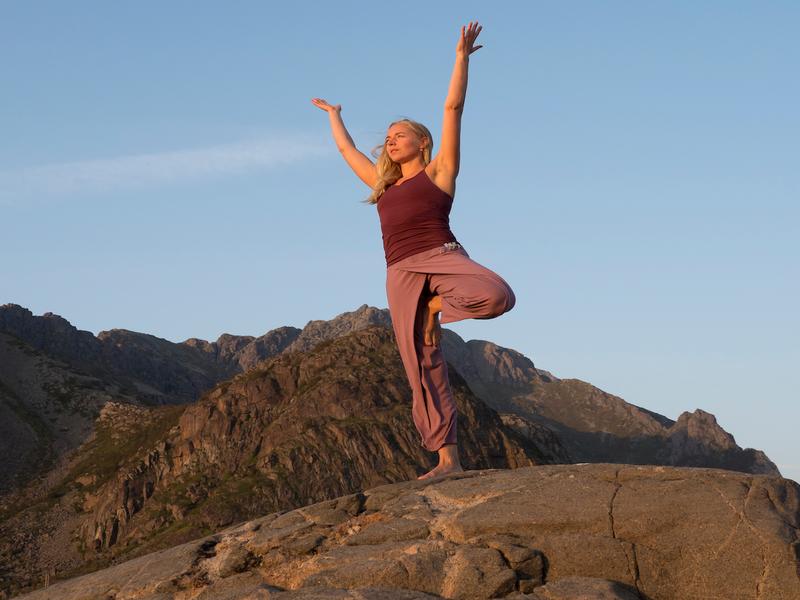 A woman doing yoga while on a hike in Lofoten, Northern Norway