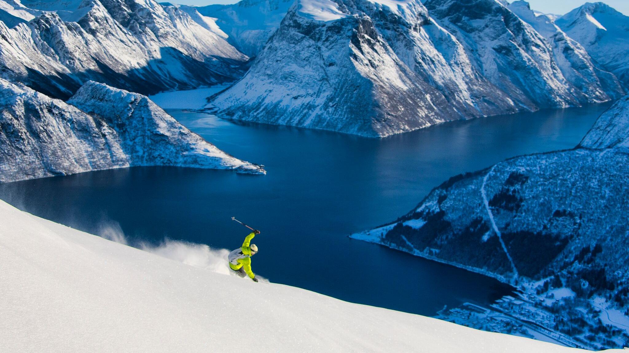 A ski tourer on their way down the mountain towards the Hjørundfjord in Fjord Norway