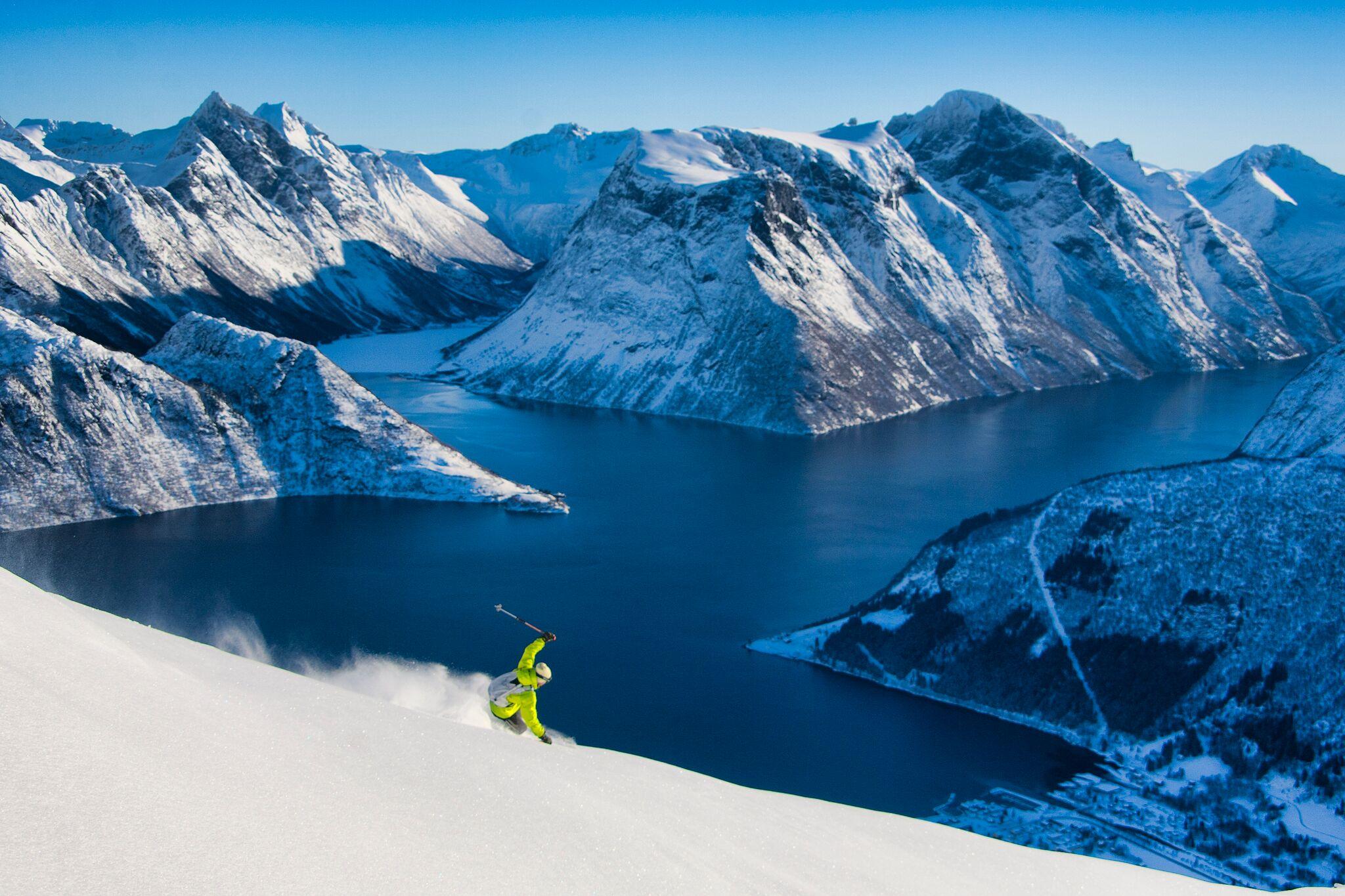 A ski tourer on their way down the mountain towards the Hjørundfjord in Fjord Norway