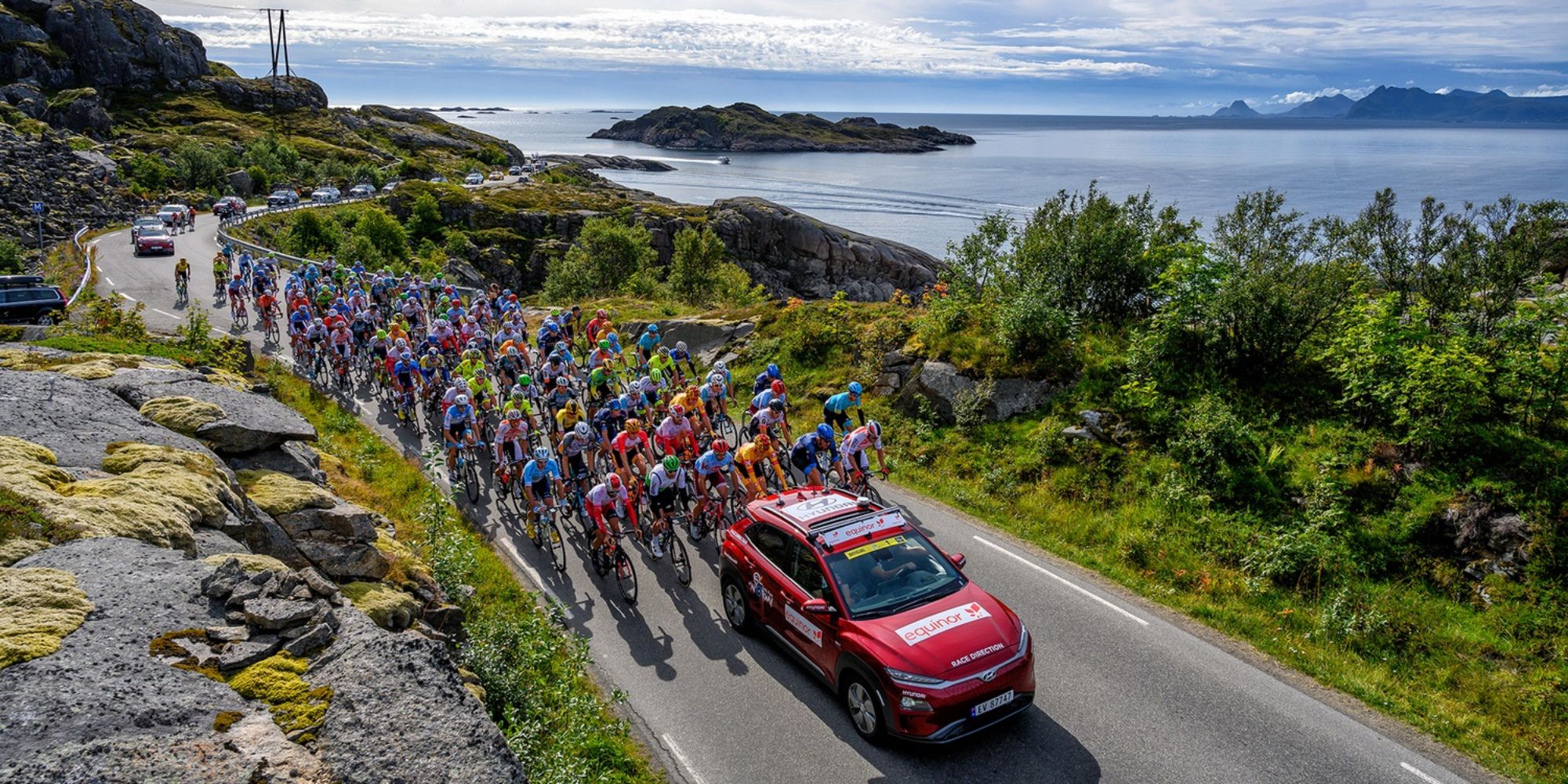 Professional bike riders cycling on a scenic road on Lofoten in Norway