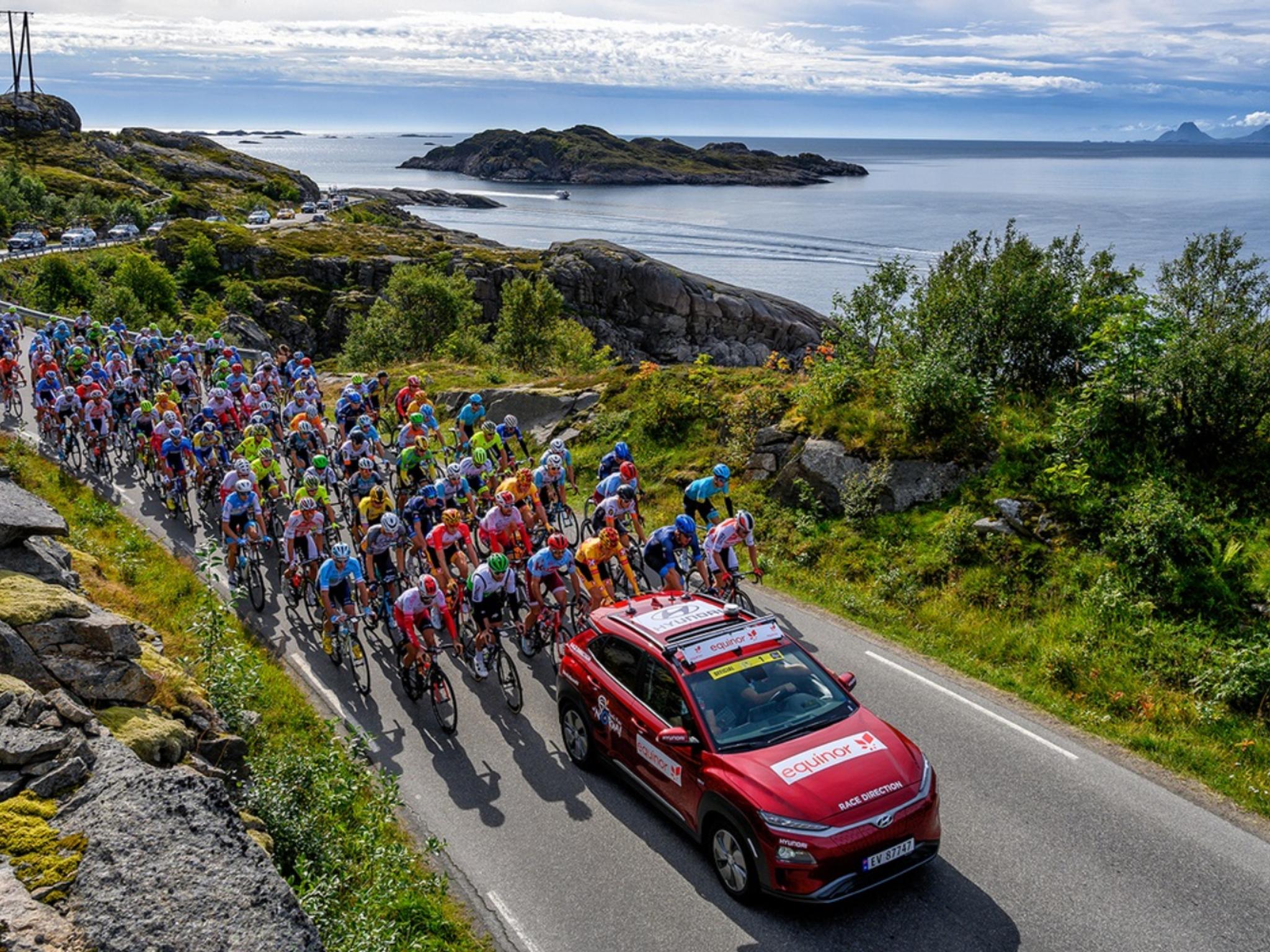 Professional bike riders cycling on a scenic road on Lofoten in Norway
