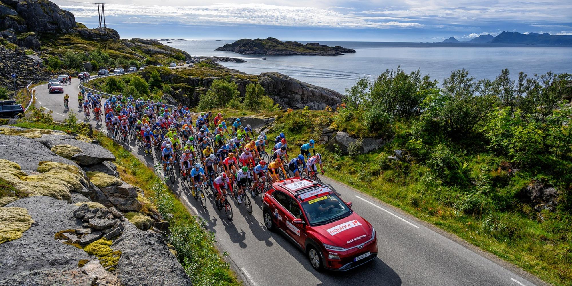Professional bike riders cycling on a scenic road on Lofoten in Norway