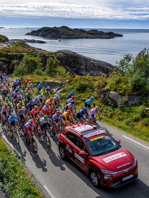 Professional bike riders cycling on a scenic road on Lofoten in Norway