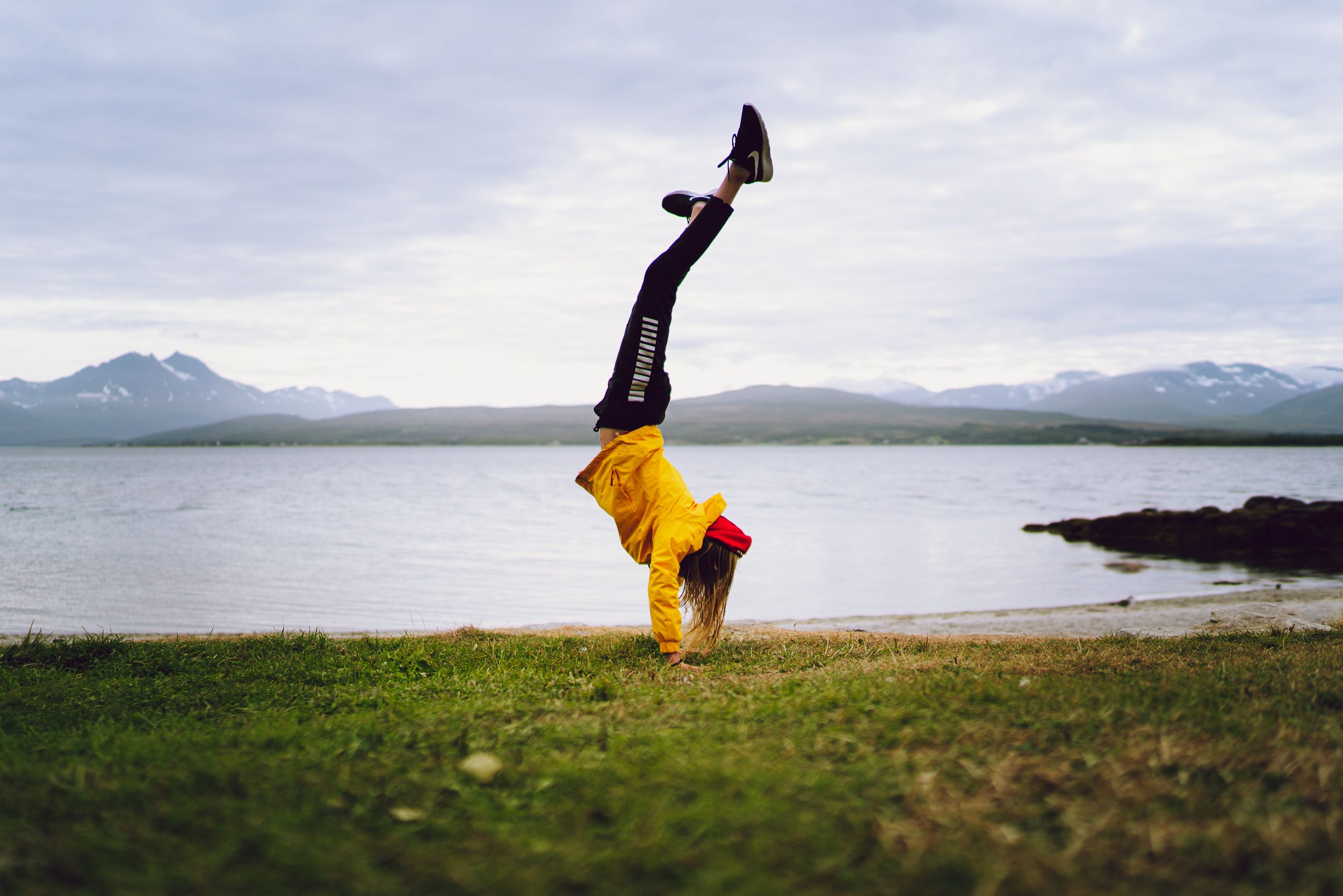 Woman doing a handstand in Telegrafbukta bay in Tromsø, Northern Norway