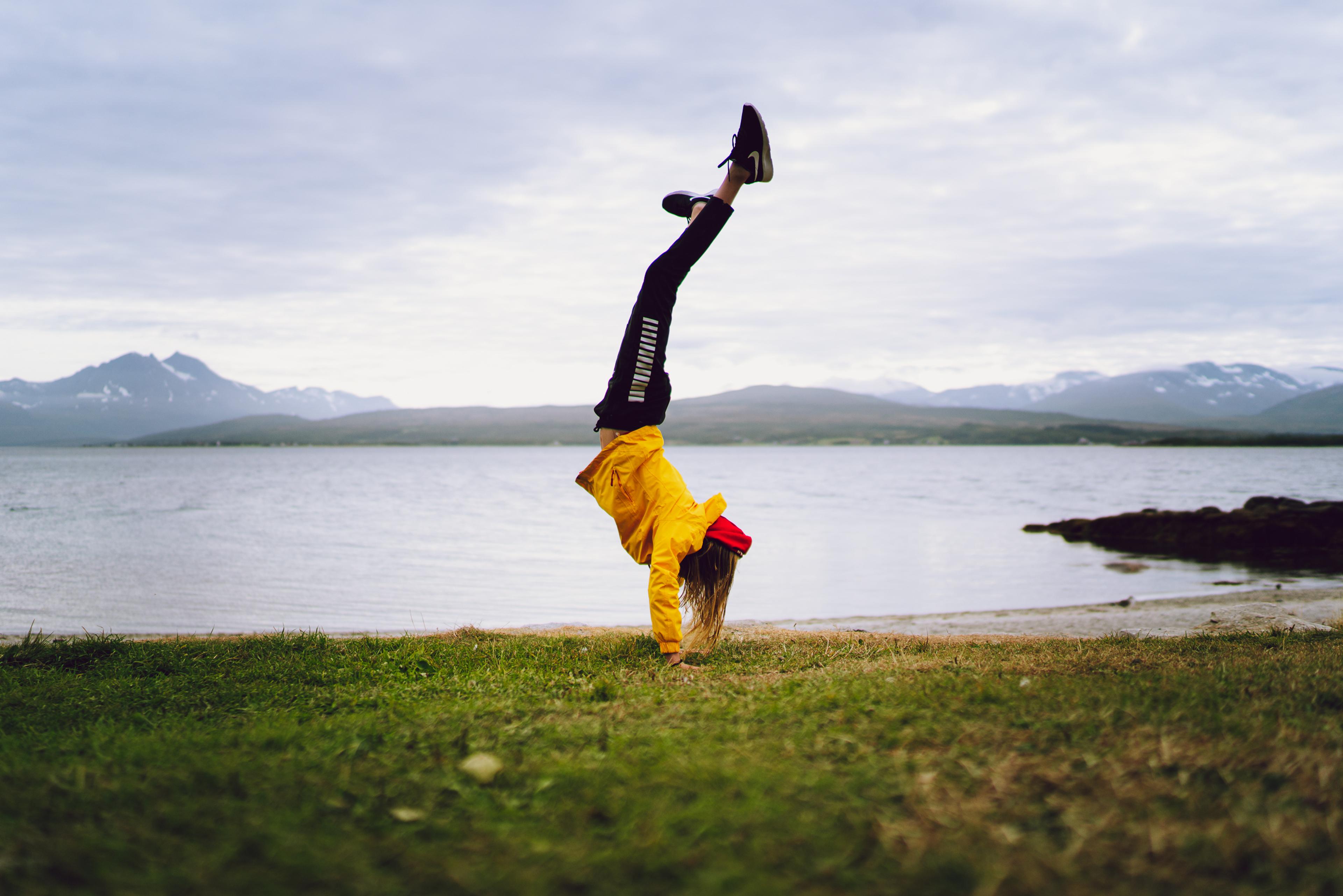 Woman doing a handstand in Telegrafbukta bay in Tromsø, Northern Norway