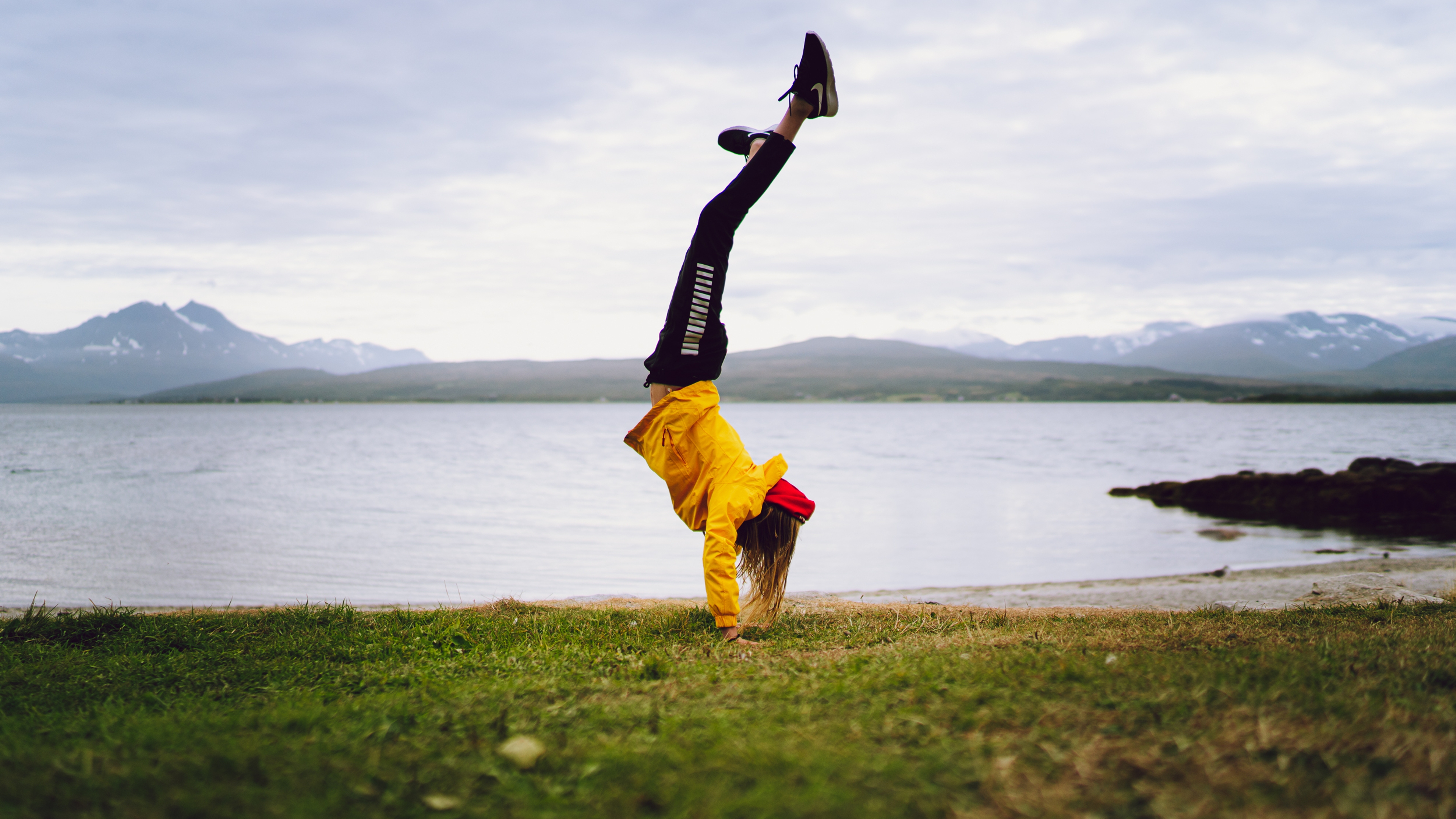 Woman doing a handstand in Telegrafbukta bay in Tromsø, Northern Norway
