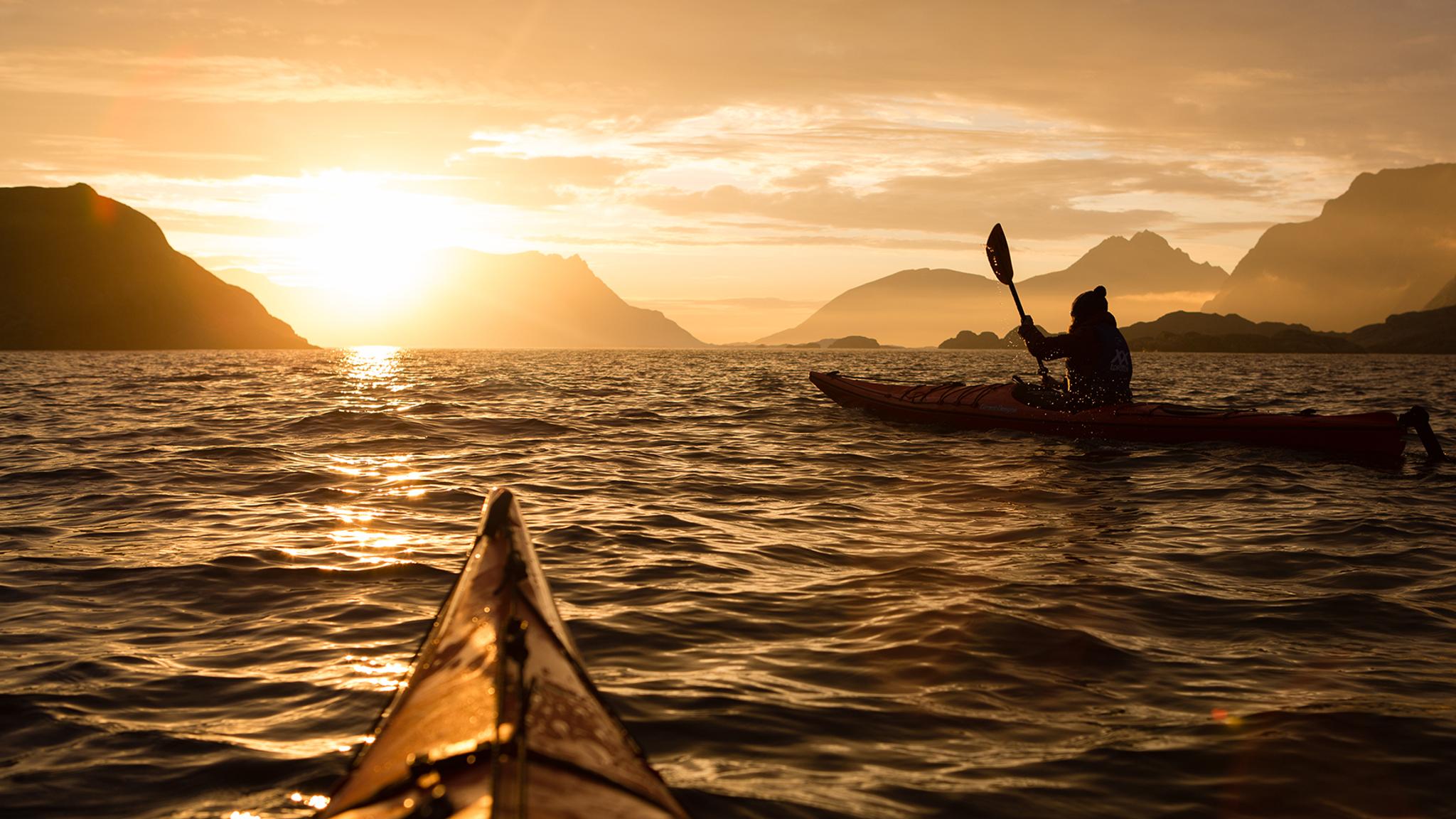Kajakpaddling under midnattssolen nära Lofoten, norra Norge