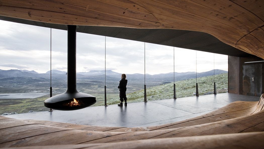 A person looking at the view from inside the Viewpoint Snøhetta in Hjerkinn.
