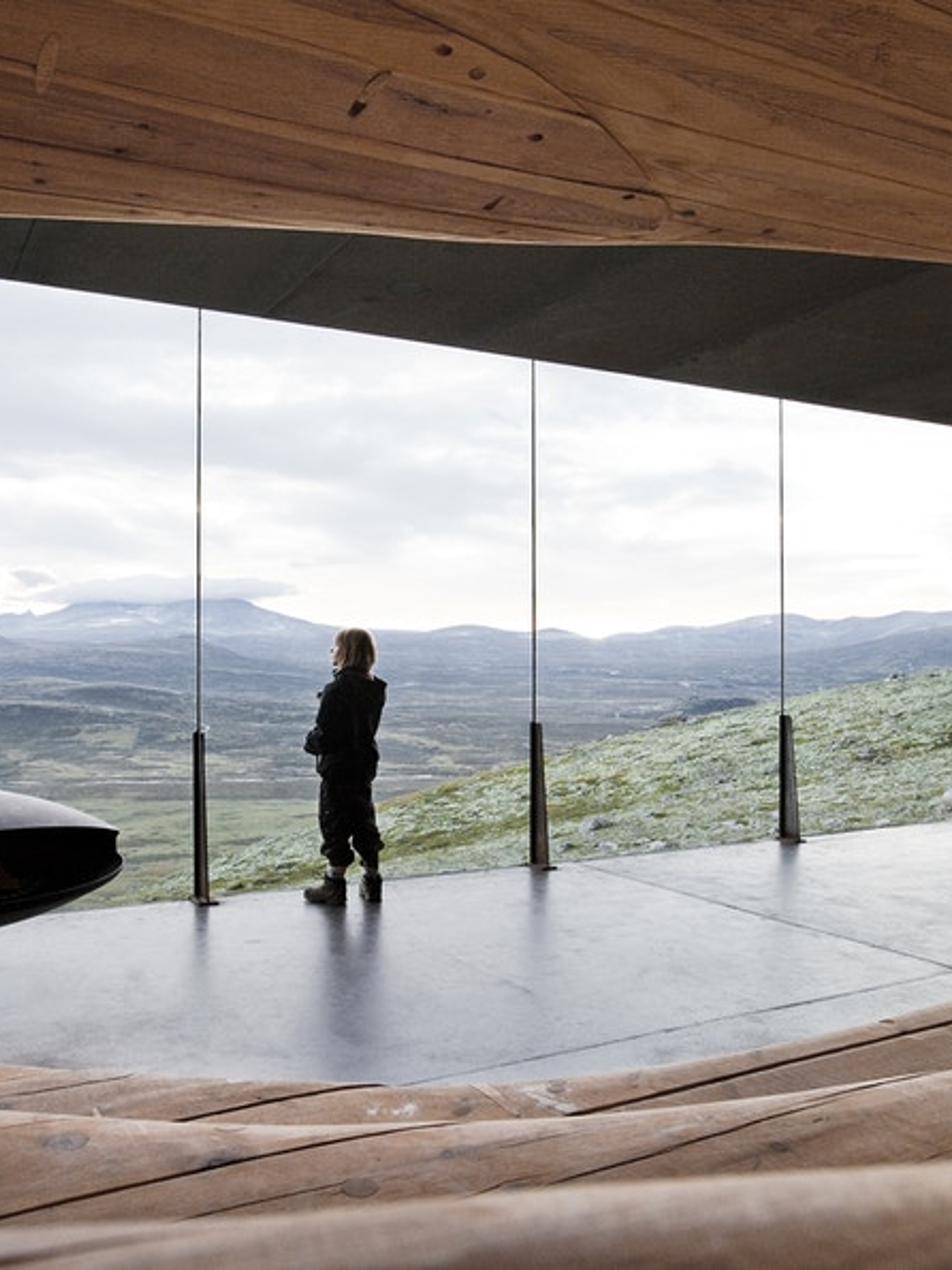 A person looking at the view from inside the Viewpoint Snøhetta in Hjerkinn.