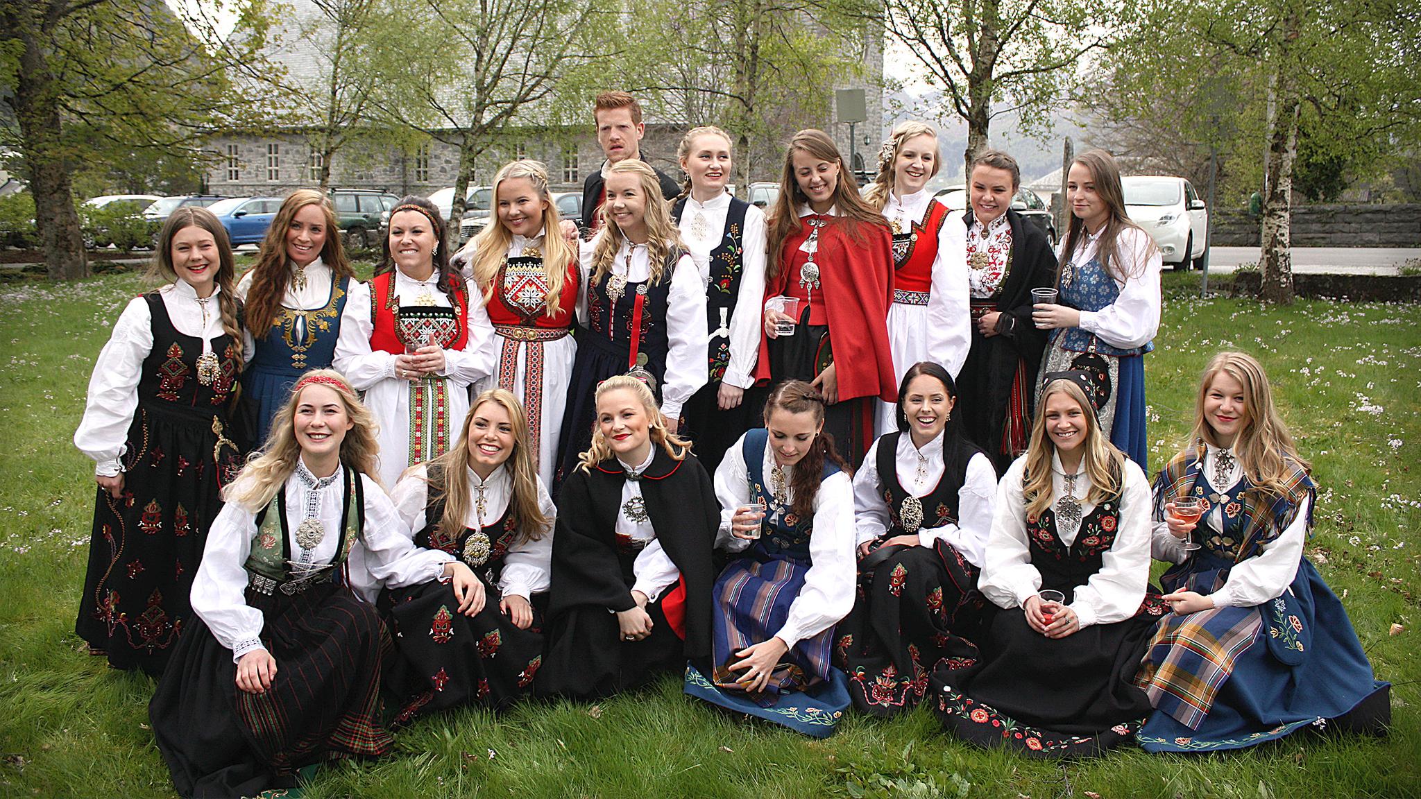 Many women and a man in different bunads, traditional costumes on graduation in Volda in Fjord Norway