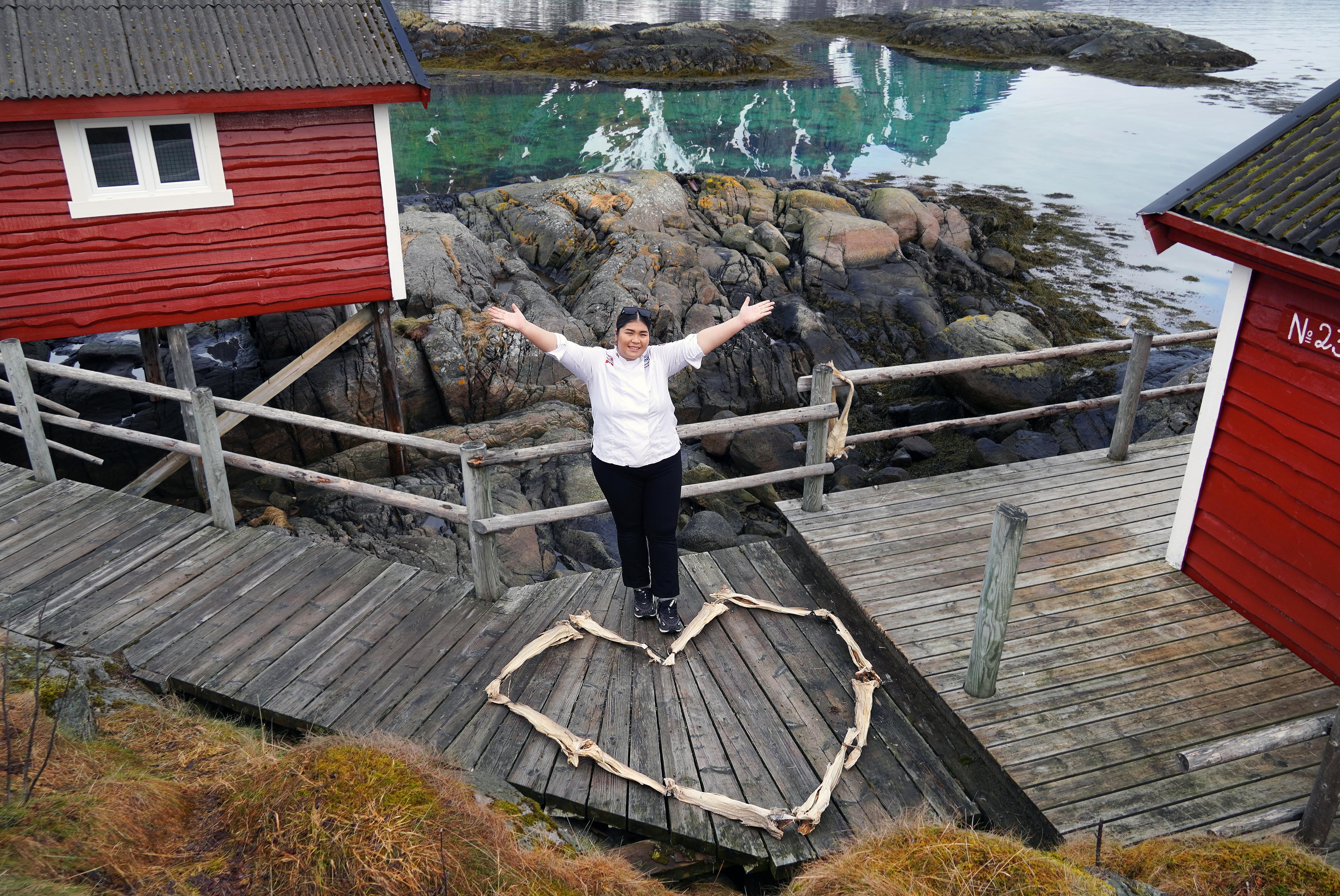 Stockfish heart and woman chef in front of a red cabin