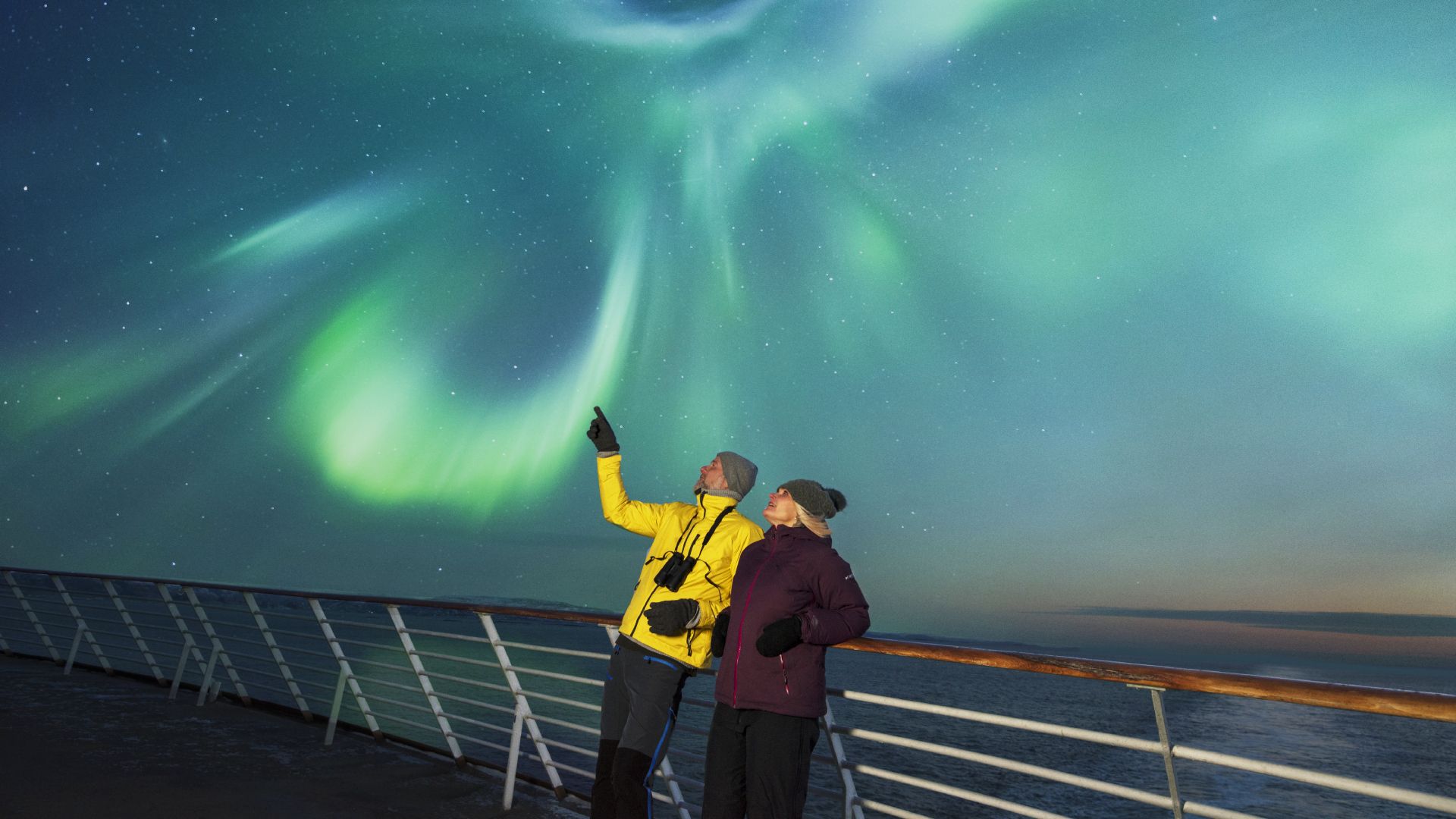 Couple watching the northern lights from deck at Hurtigruten