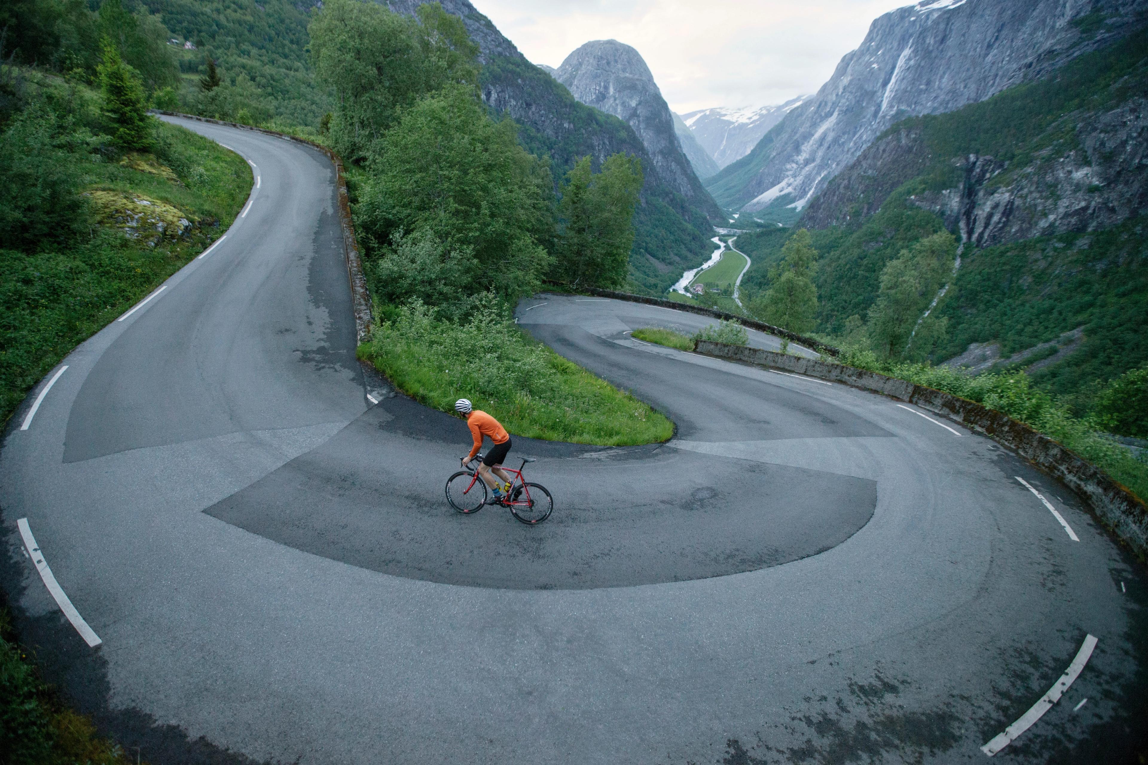 En person cykler op ad landevejen Stalheimskleiva i Voss, Norge - en top 5 cykelrute i de norske fjelde