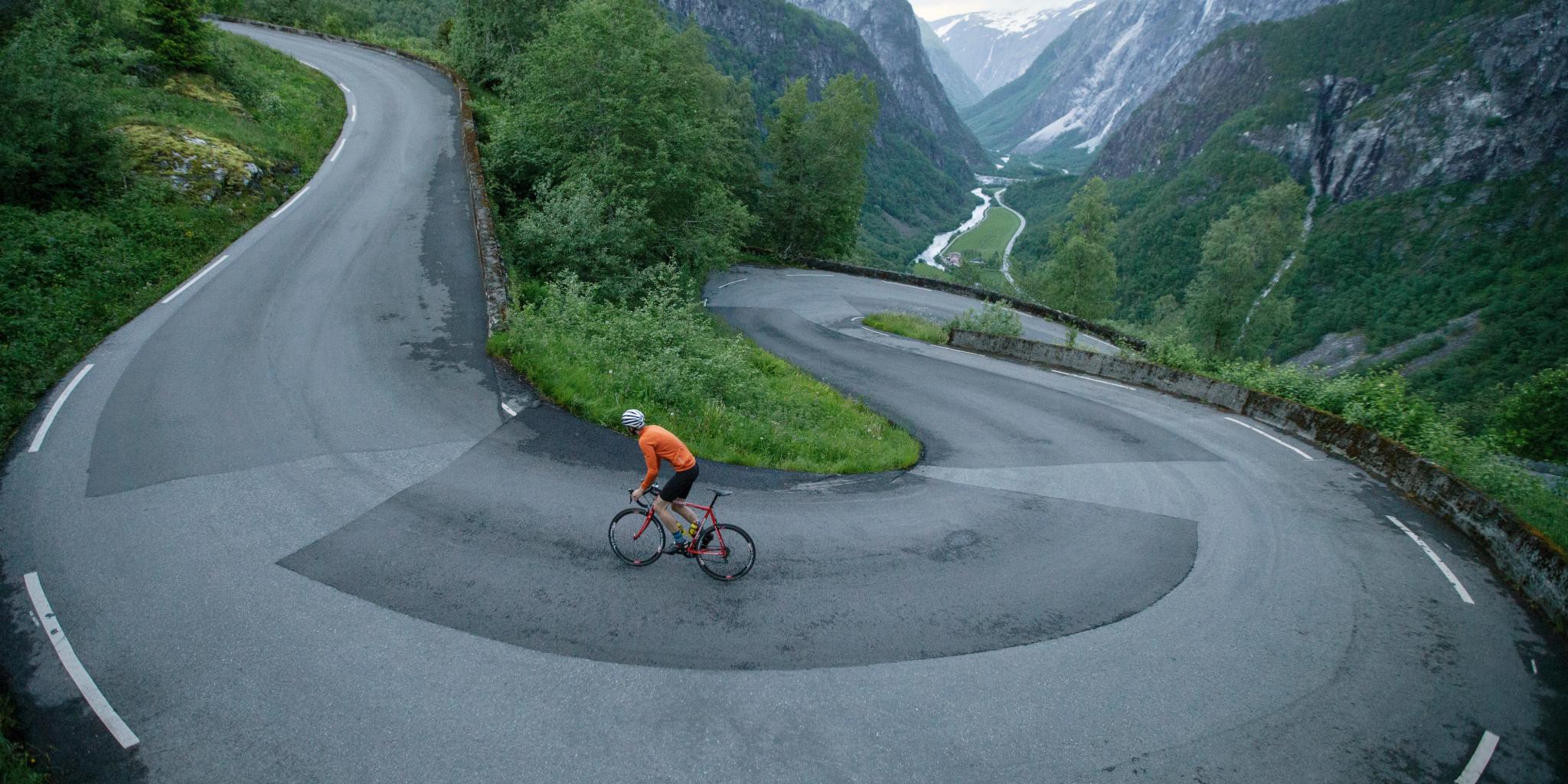 En person cyklar uppför Stalheimskleiva, en av Norges 5 bästa cykelleder i fjällmiljö, i Voss i regionen Fjord Norge (Vestlandet)