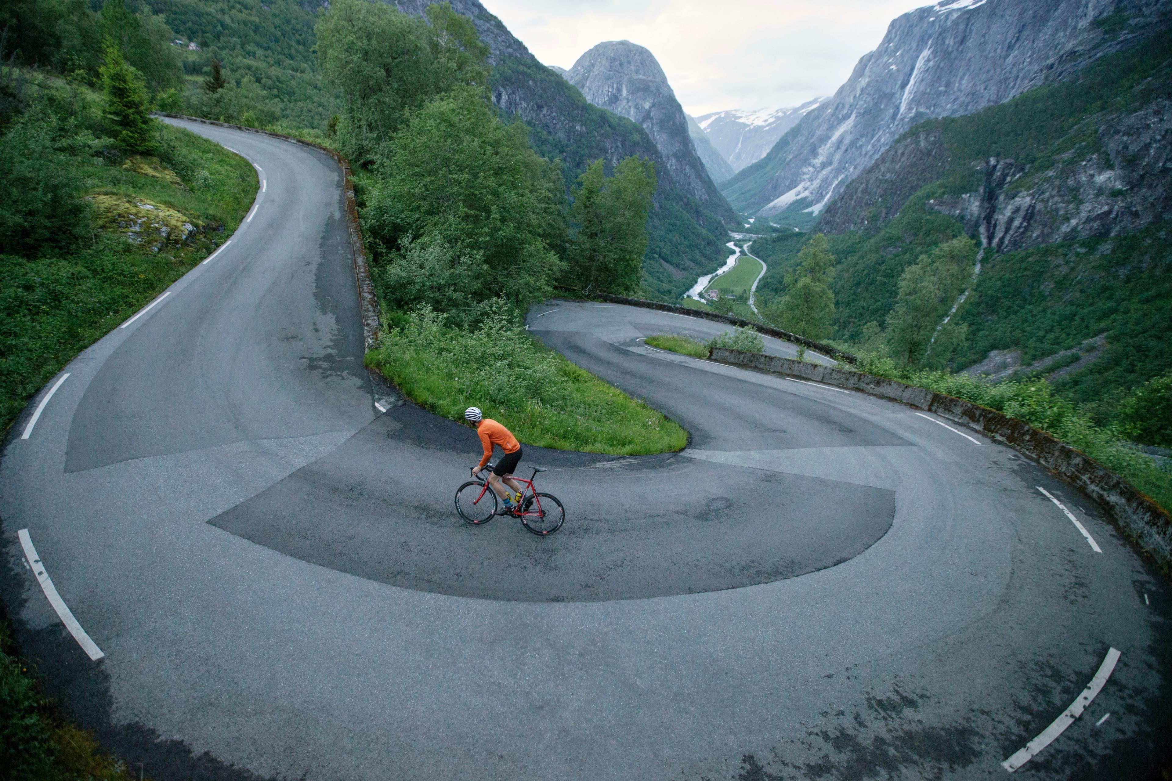 En person cykler op ad landevejen Stalheimskleiva i Voss, Norge - en top 5 cykelrute i de norske fjelde