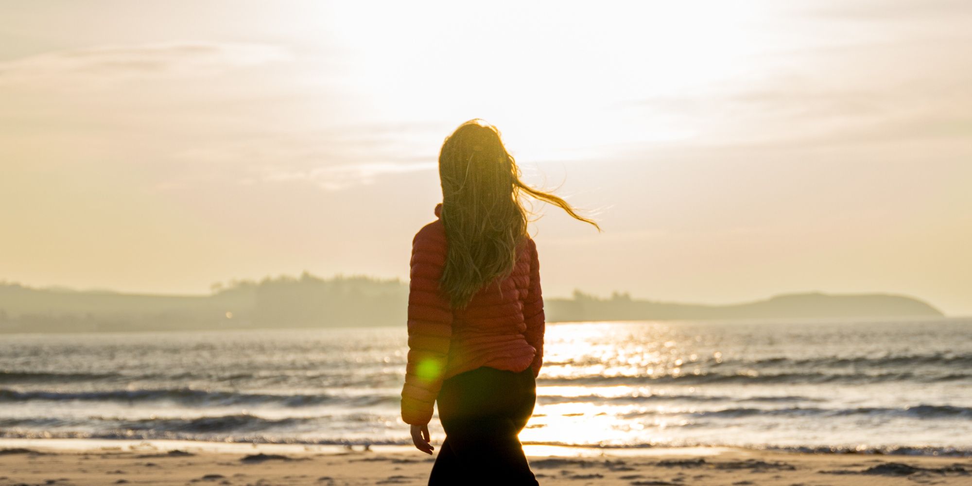 A woman enjoying the beautiful sunset at Solastranden, Sola Beach in Stavanger
