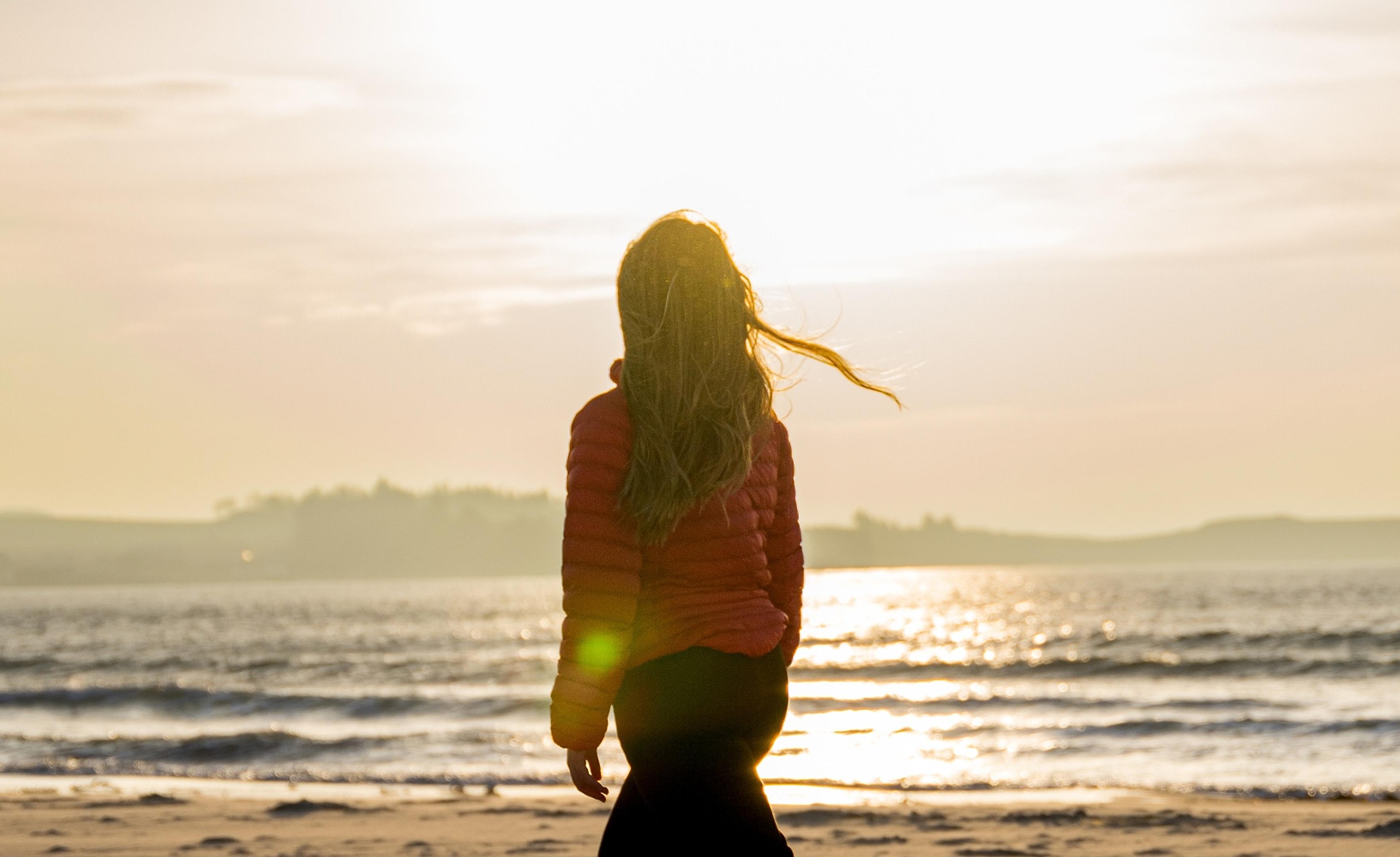 A woman enjoying the beautiful sunset at Solastranden, Sola Beach in Stavanger