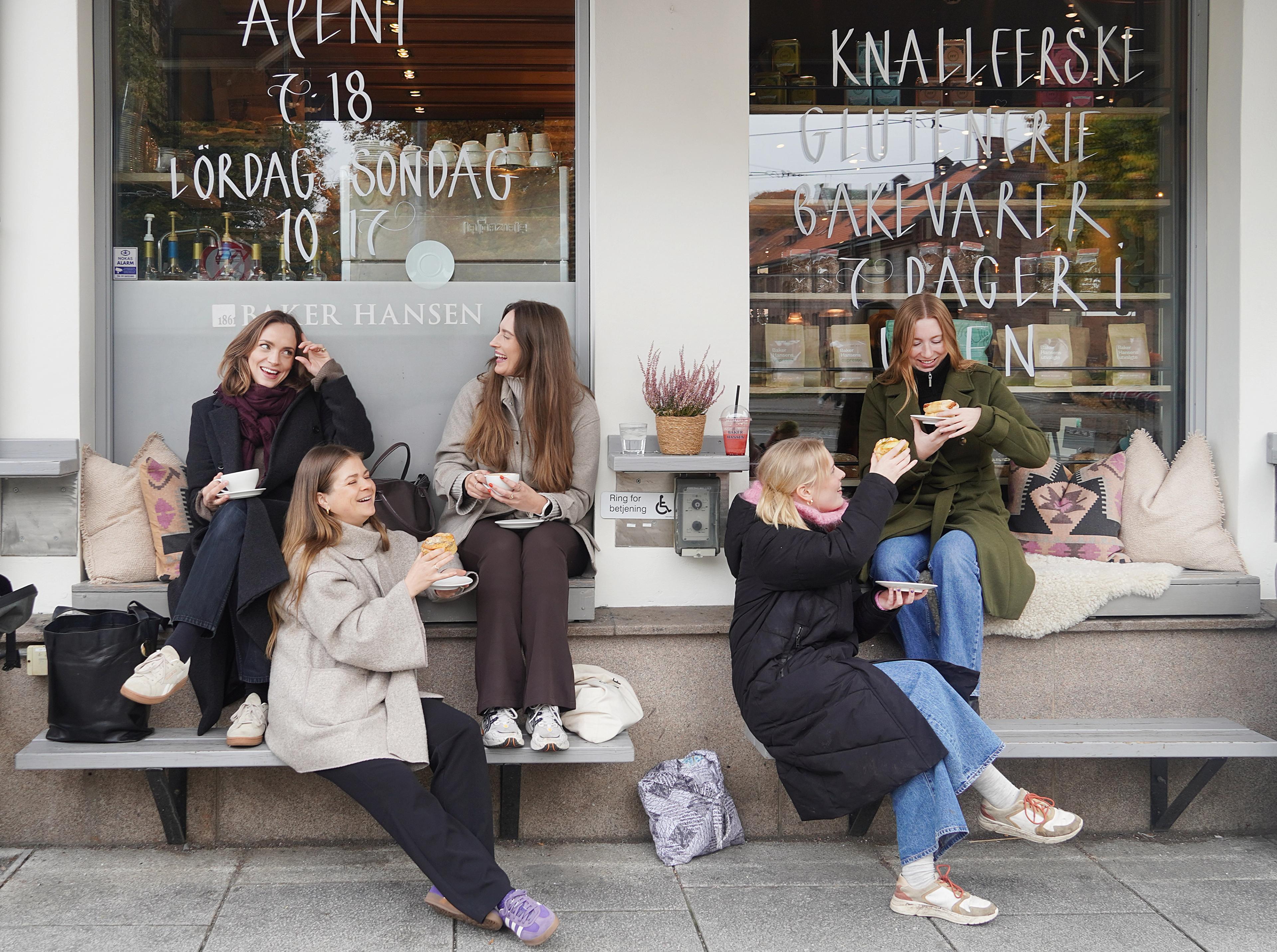Women drinking coffees outside a bakery